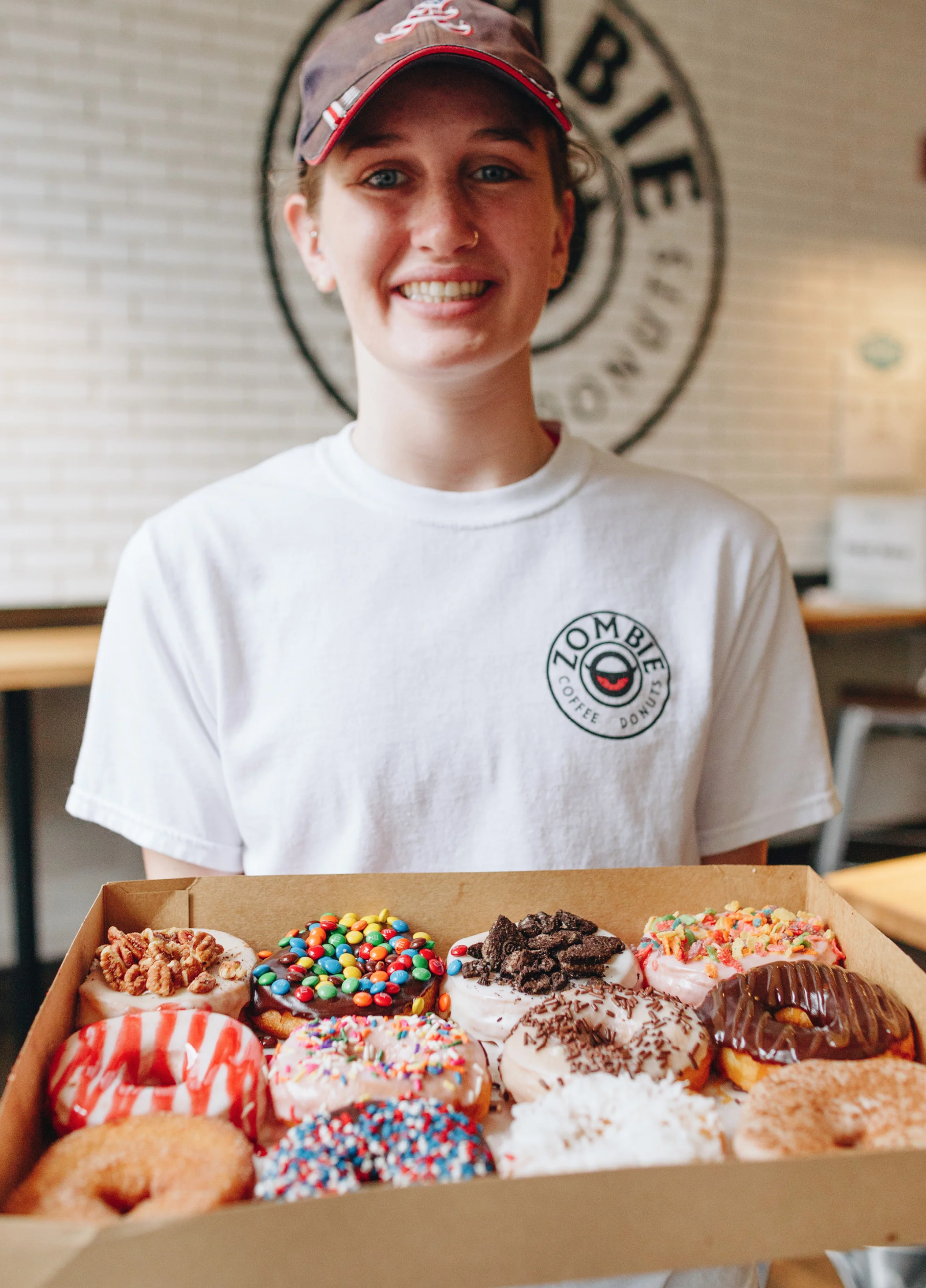 OPPOSITE Store employee and UGA student Liz Woodard holds a dozen carefully decorated Zombie doughnuts on their way to some lucky customer.