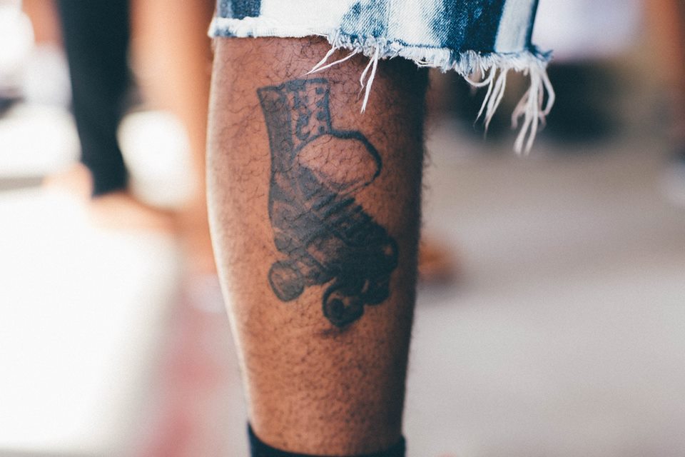   A skater shows off a tattoo of a typical hi-top Chicago style roller skating boot. Bransby Outdoor Family YMCA. Lithonia, Georgia  