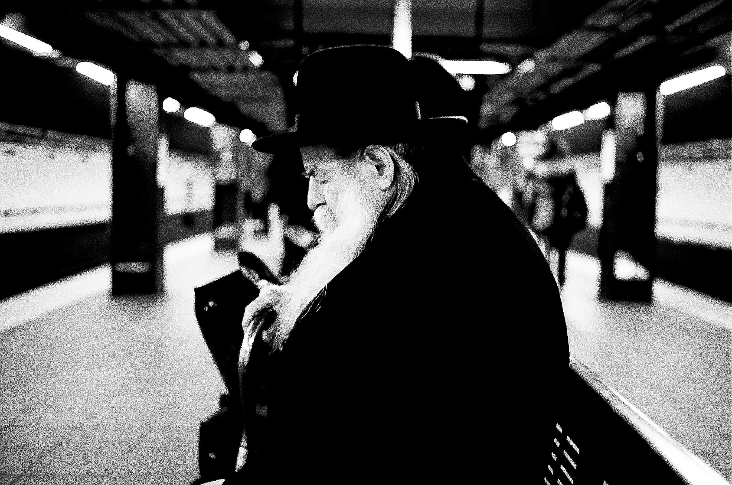   A Hasidic man takes a quick nap on the Fulton Street subway platform   