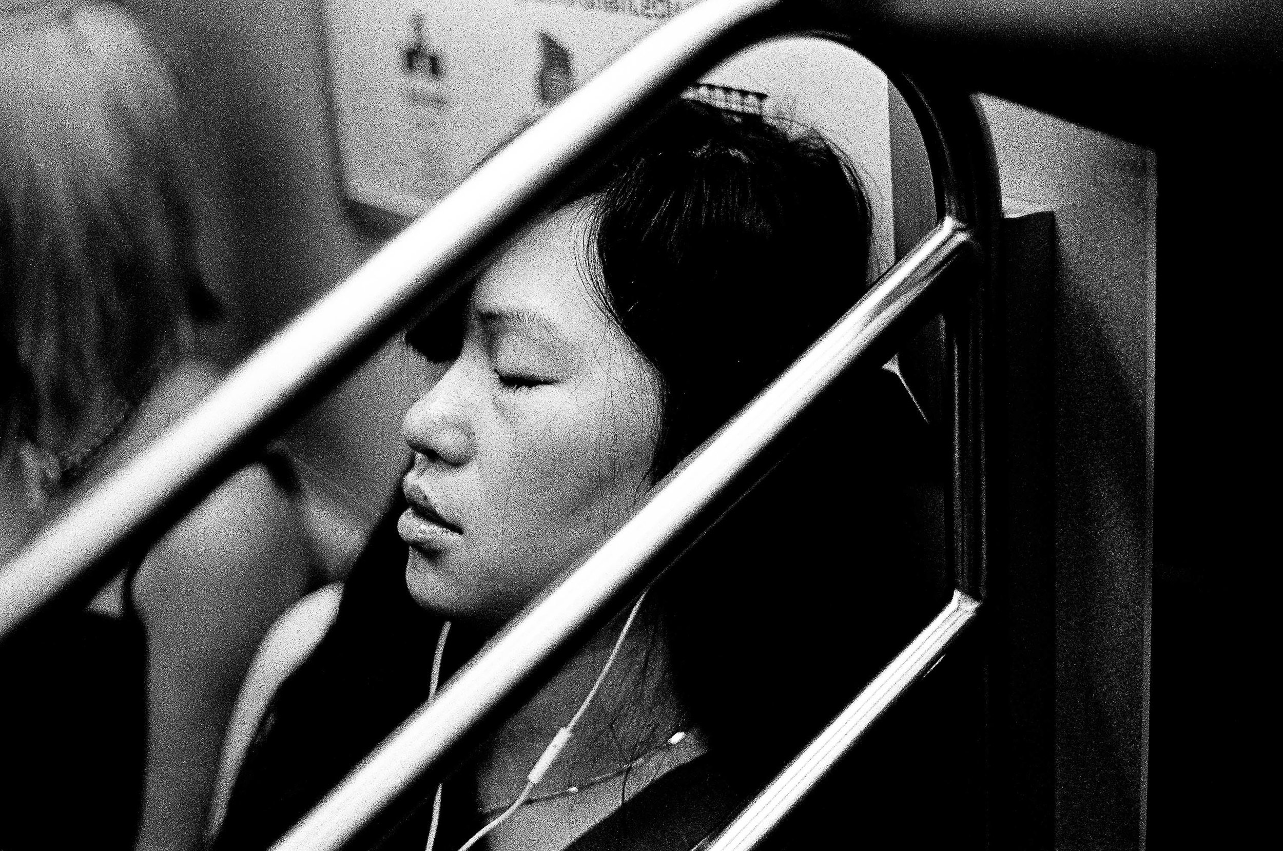   A young woman rides the E train uptown   