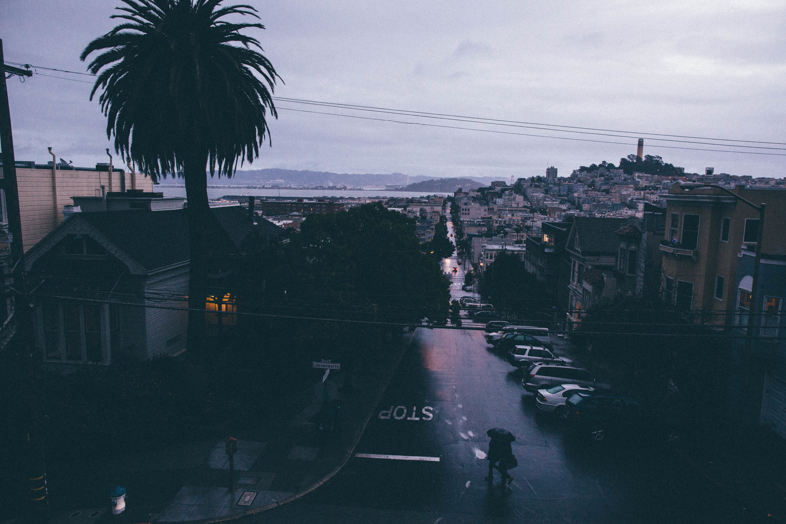 A couple gets caught in the rain on Leavenworth Street in the Russian Hill section of San Francisco. San Francisco, California. 