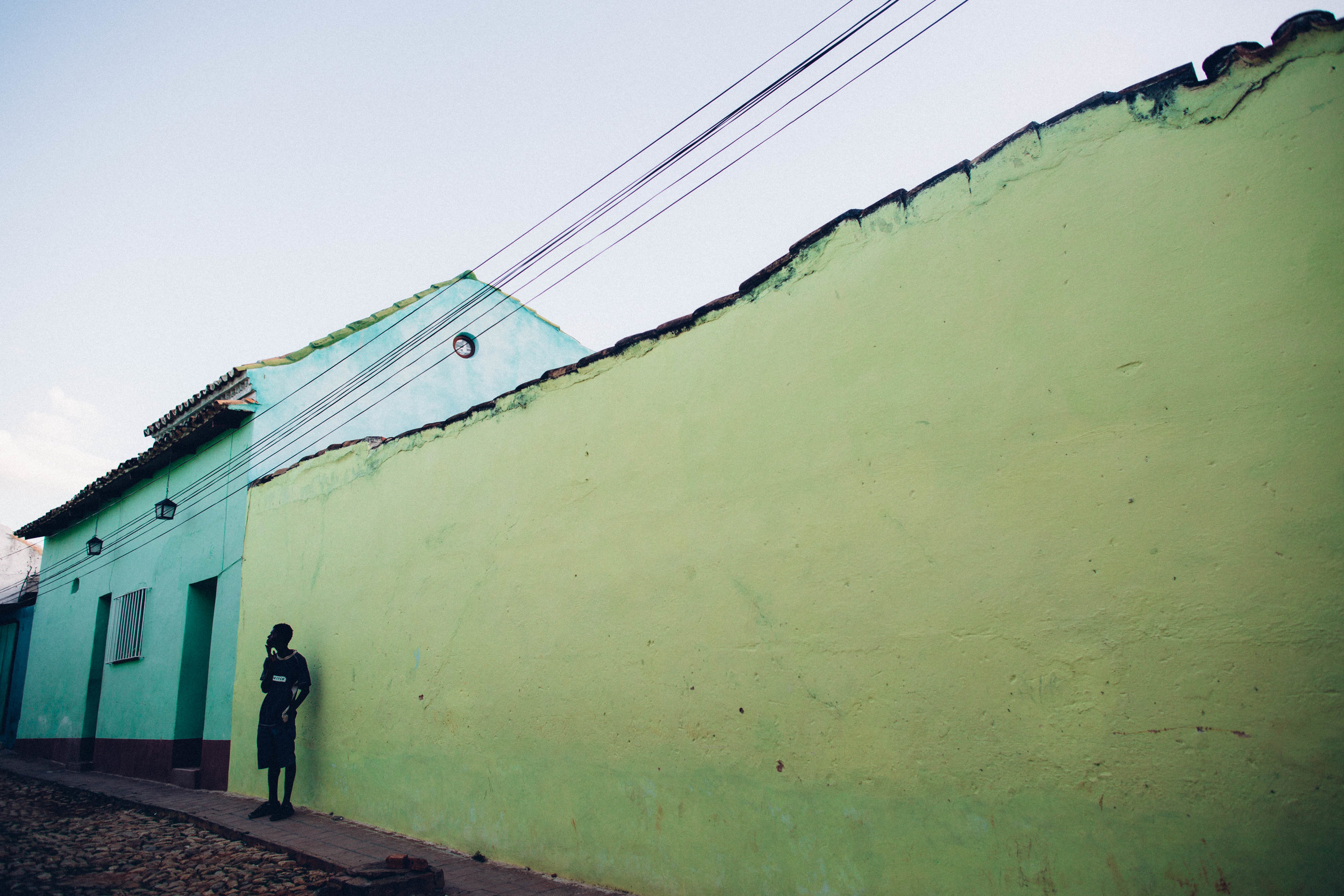   A young man deep in thought amongst the colorful houses of Trinidad. Trinidad, Cuba.  
