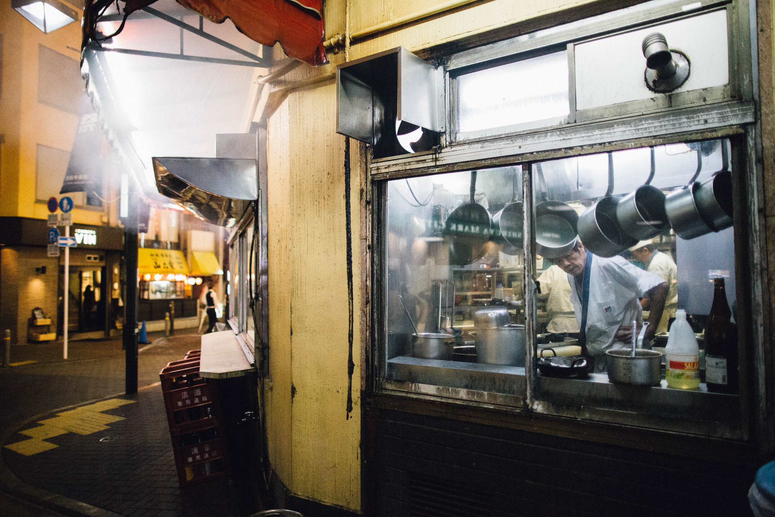 A cook peeks through a window in Tokyo, Japan.