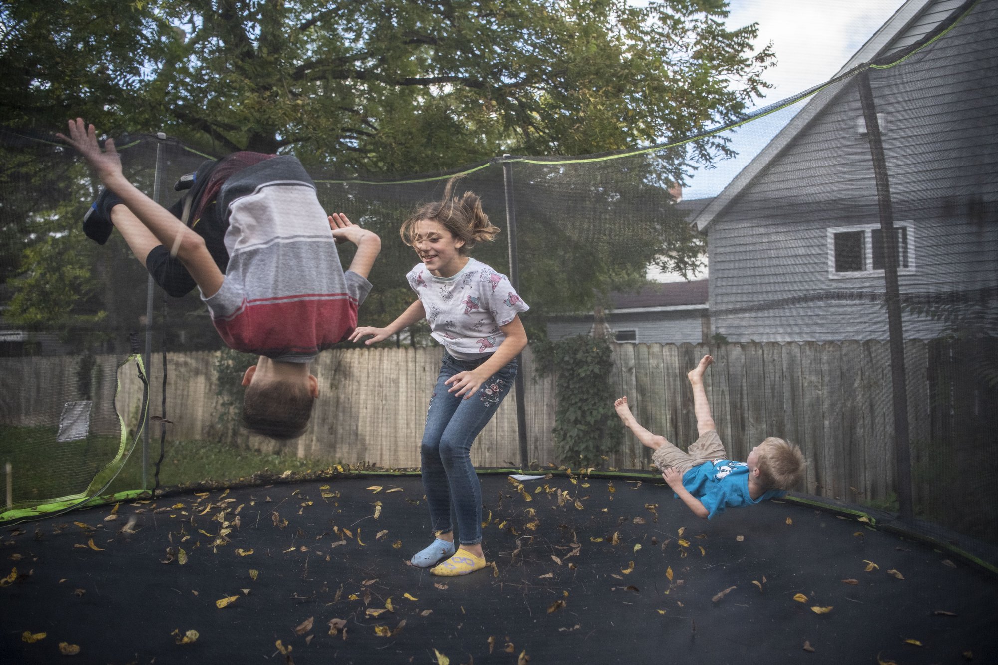  Matthew Murray, 9, Hannah Fox, 10, and Miles Murray, 4, jump on their trampoline at their home in Athens, Michigan on Monday, Oct. 4. 