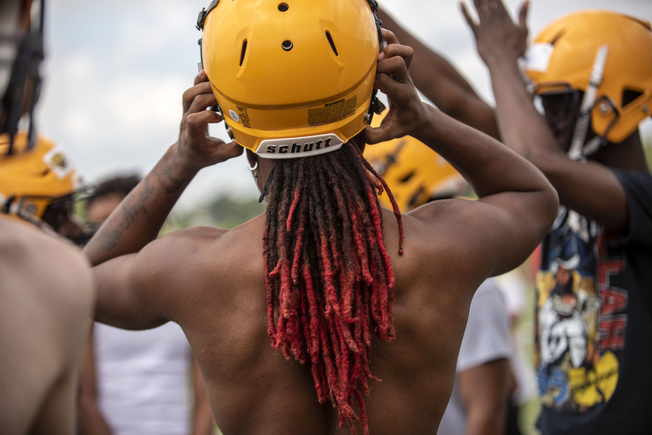  Senior O'Marion Davis adjusts his helmet as the first football practice of the season begins at Battle Creek Central High School on Monday, Aug. 10. 