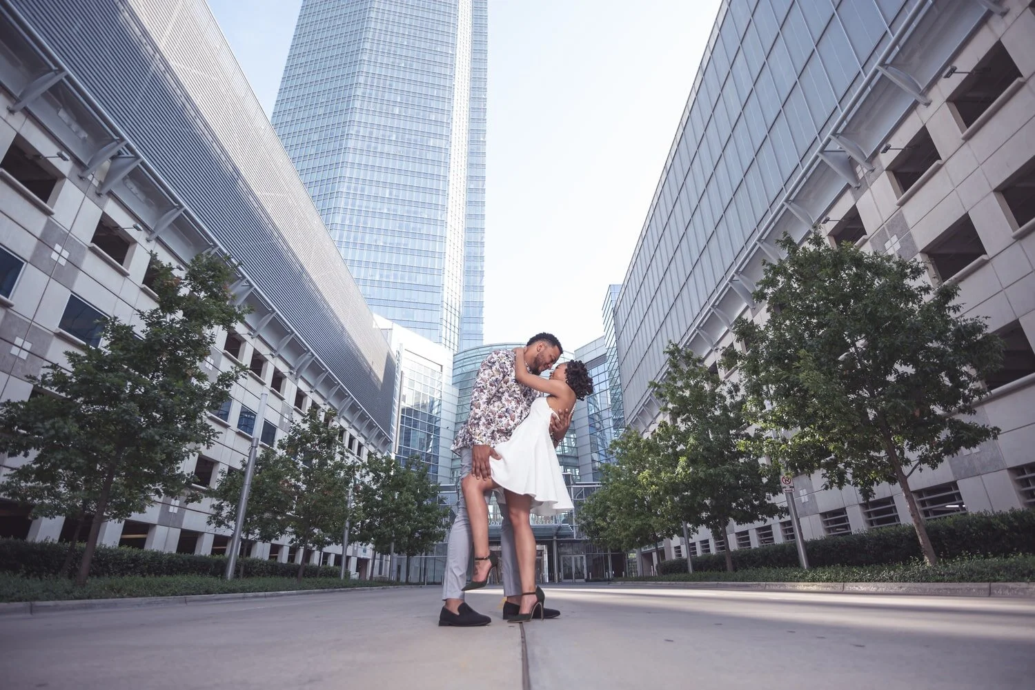 engagement-couple-dip-kiss-downtown-okc-buildings-trees.jpg