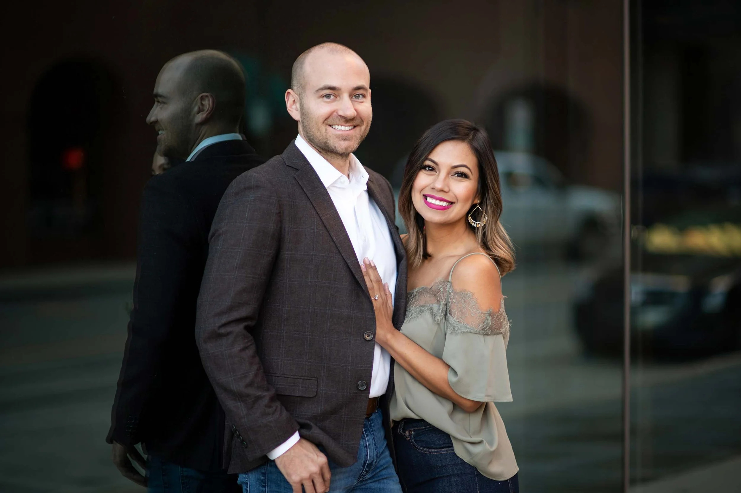 engagement-wedding-photographer-photography-okc-edmond-oklahoma-city-beautiful-couple-porait-downtown-window-reflection-smiling-chadandbriephotography.jpg
