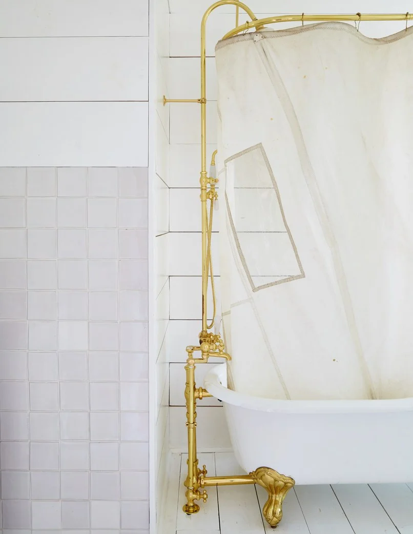 Exposed brass plumbing fixtures compliment the beauty and functionality of a cast iron tub in this bathroom designed by Leanne Ford.Photo: Nicole Franzen