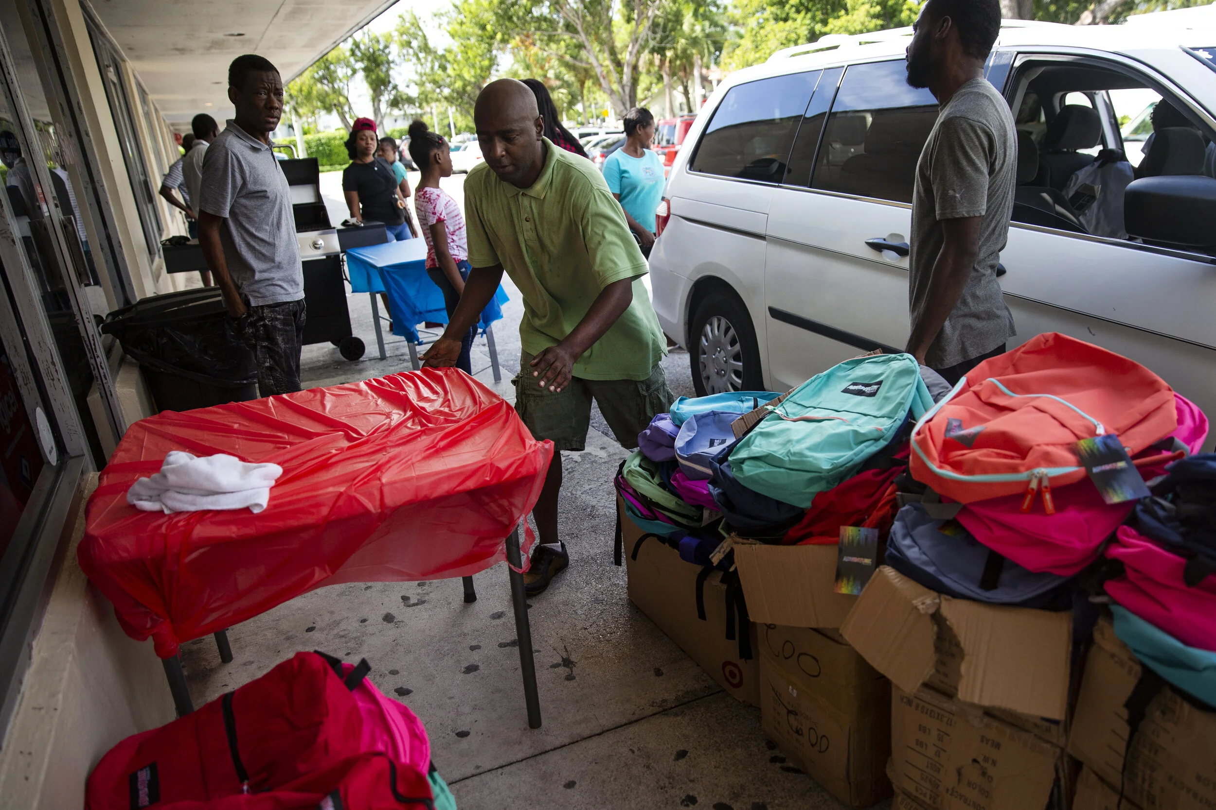  Agur Senecharles and fellow River Park residents sets up tables outside Excelsior barber shop for a back to school event, Saturday, Aug. 10, 2019, in River Park. 