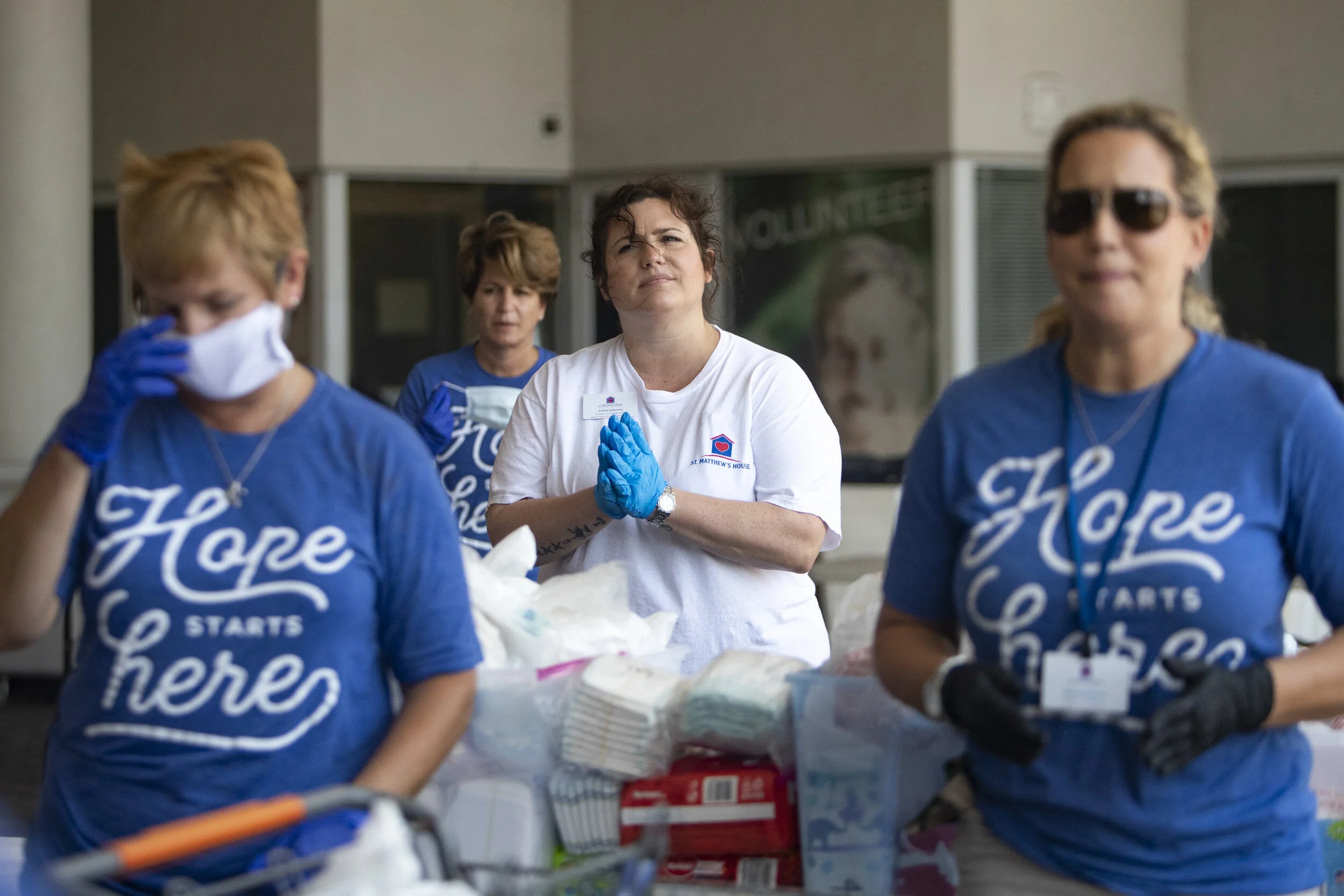  Beth Ware, center, vice president of human capital at St. Matthew's House, joins residents and staff members in a prayer before distributing food to Naples residents at St. MatthewÕs House in East Naples on Thursday, April 9, 2020. 