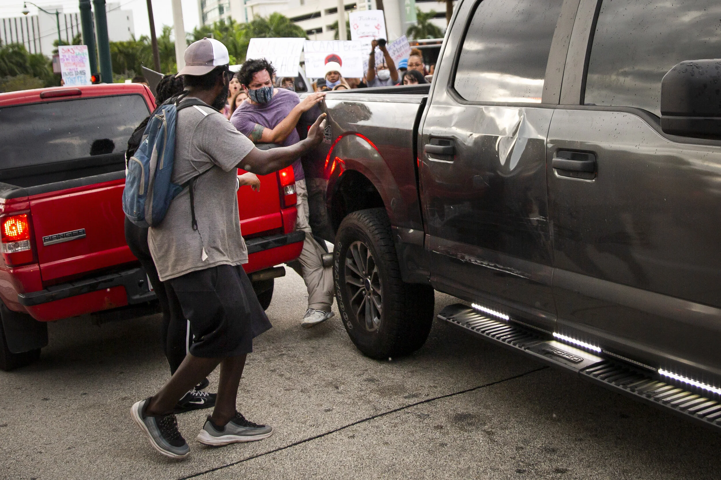 Diego Fernández, 29, is squeezed between a red pick-up truck waiting at U.S. 41 and Airport Pulling Road in East Naples as a Collier County Sheriff’s Office vehicle moves through a crowd of protesters, Monday, June 1, 2020.  