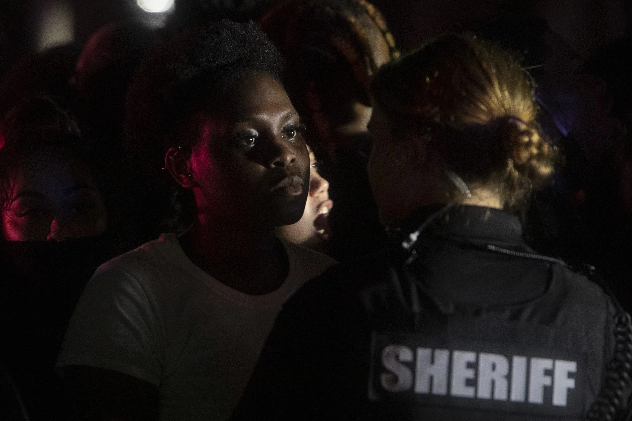 Loissa Antoine of Naples, Florida, stand in front of a line of Collier Count Sheriff’s Office deputies, Monday evening, June 1, 2020, on U.S. 41 in East Naples, Florida.