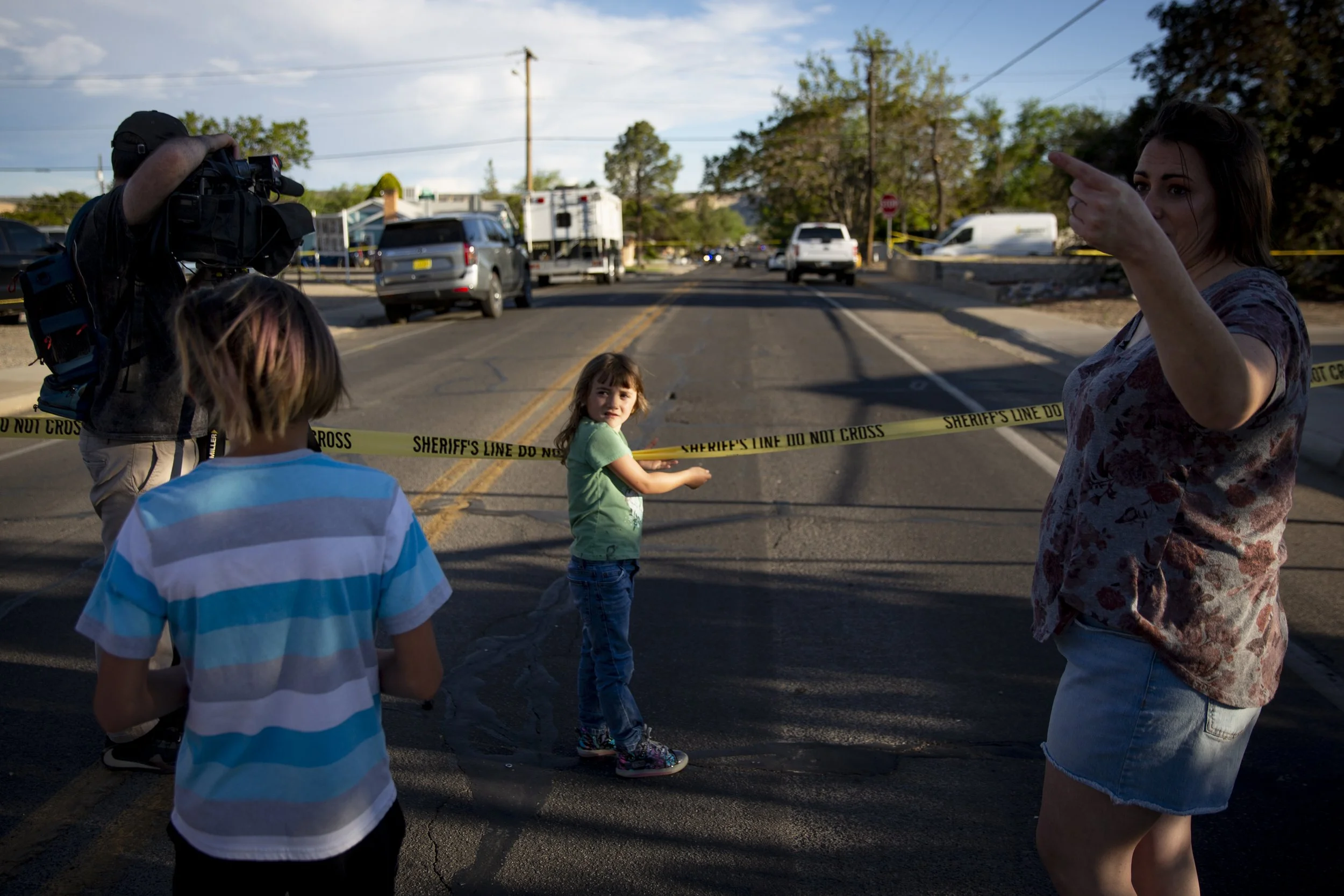  Community members watch as authorities investigate the scene of a deadly shooting on North Dustin Avenue in Farmington, N.M.  on Monday, May 15, 2023. Officials say four people were killed and 10 injured, including two police officers. The shooter w