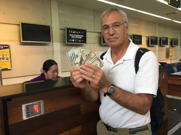 The currency in Cambodia is the US Dollar. Here is Michael handing over the ransom of $175 crisp US Dollars to get our luggage on board our flight.