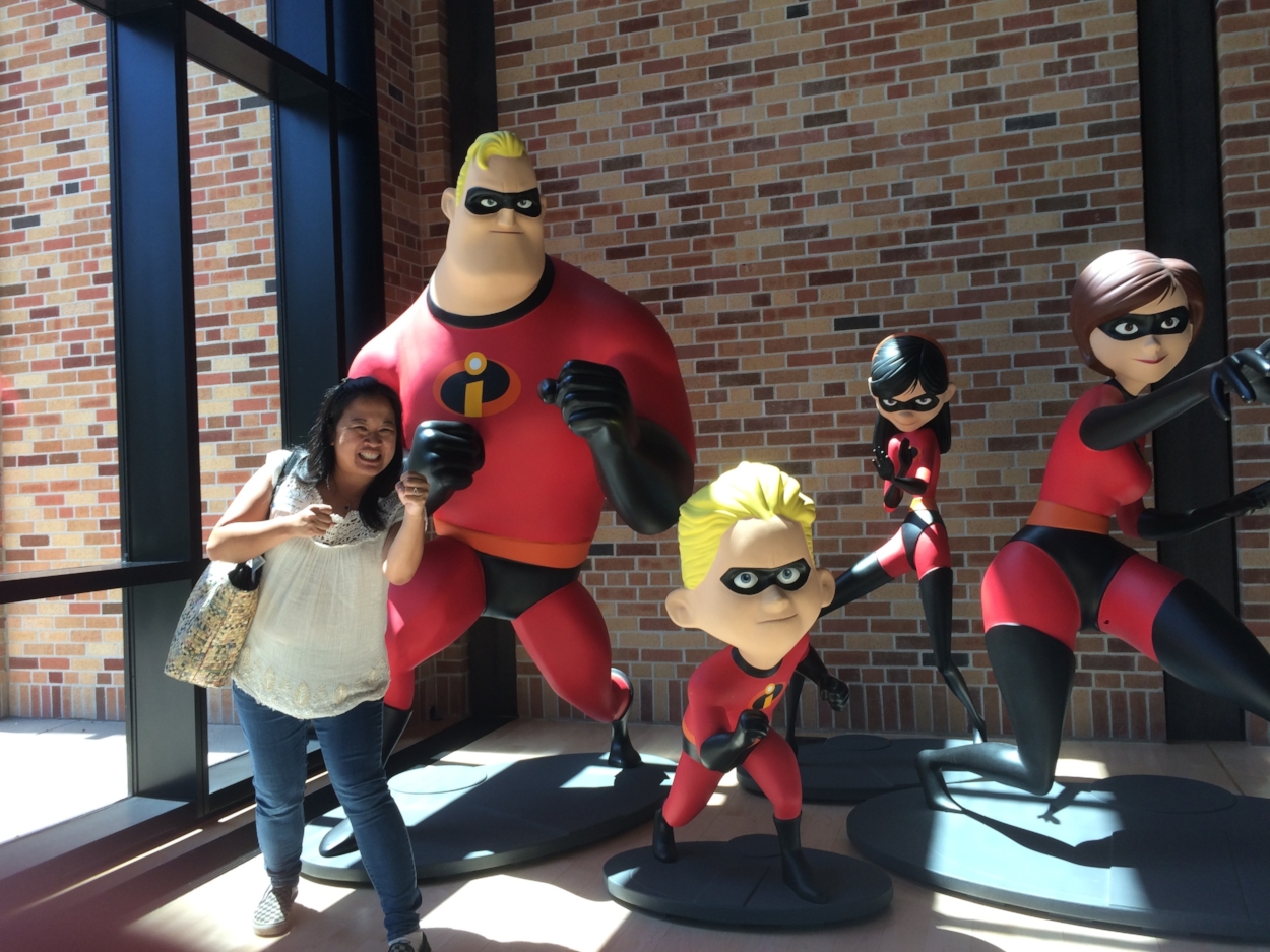 Dr. Melanie posing with The Incredibles at Pixar Animation Studios