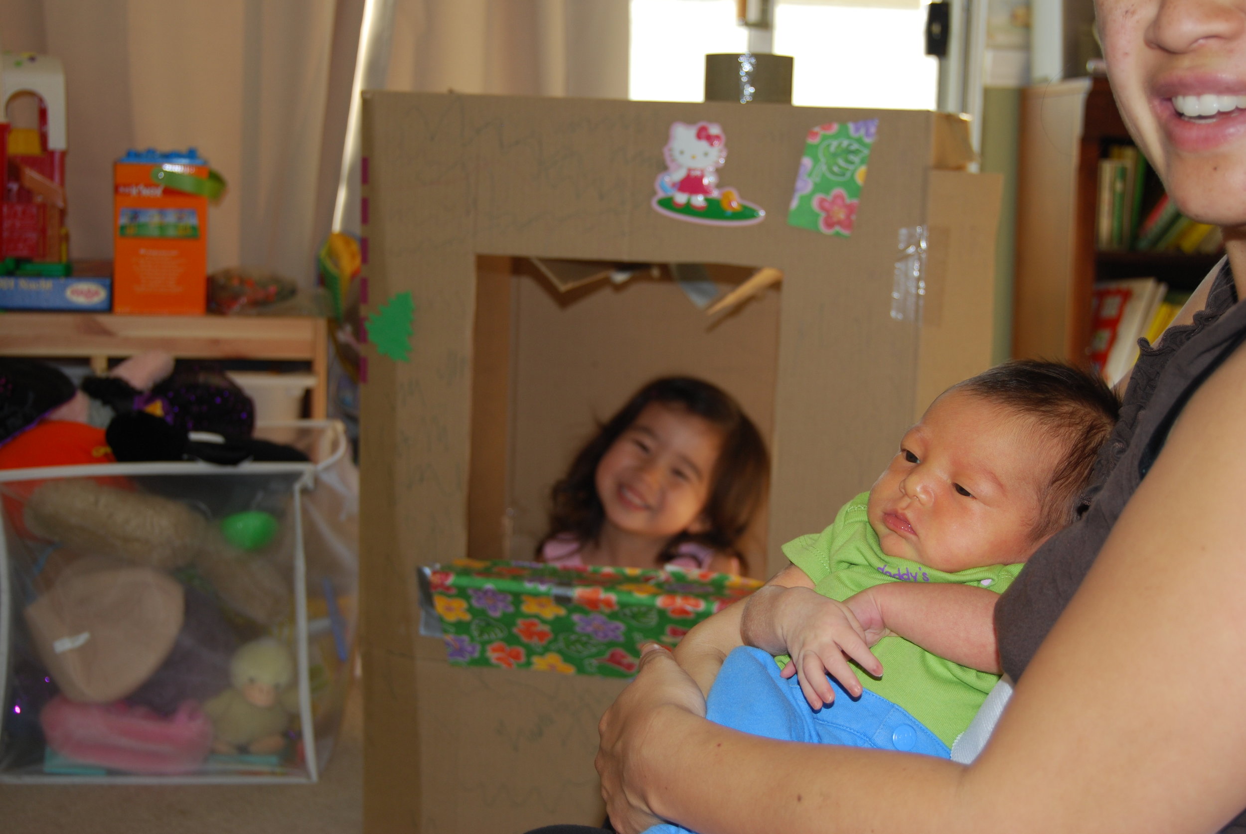 Mini Me playing in her bakery box while I snuggle up with a newborn Little Lion. See, she's even yellow! (with jaundice) Posted with permission.