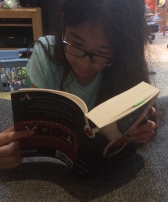 Mini Me finishing up Twilight last week. See the bookmark where I'm at the beginning? Please ignore the laundry and mess in background.