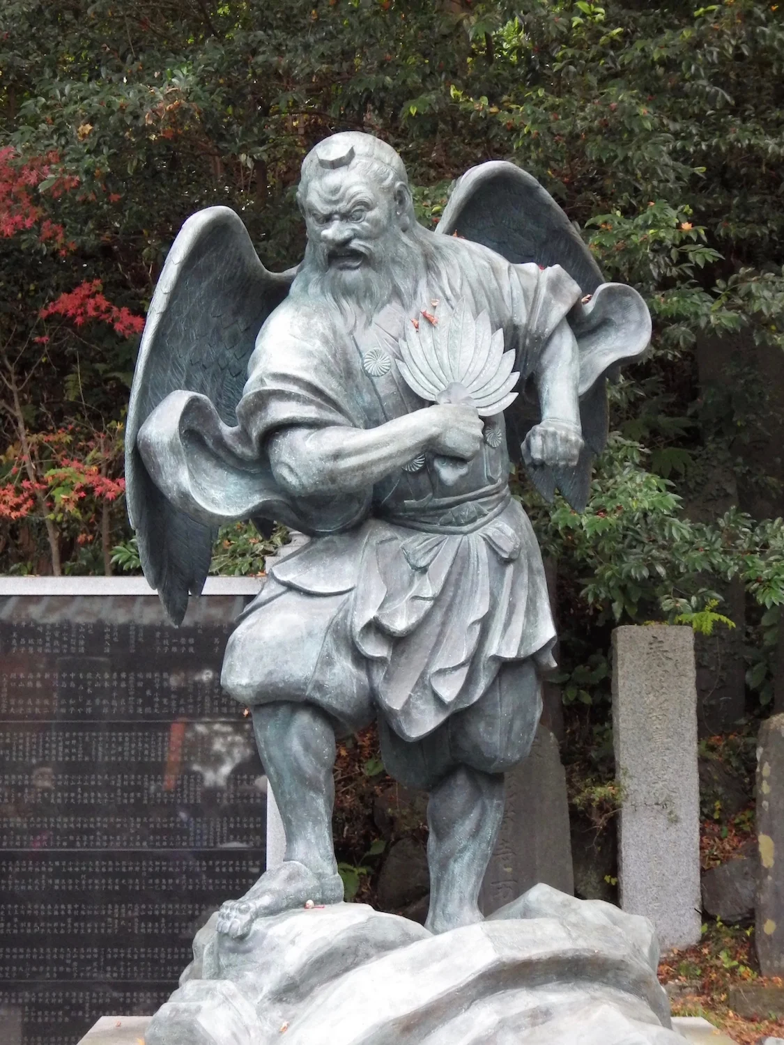One of the two statues. This tengu holds a hand fan, or uchiwa , to sweep away bad luck.