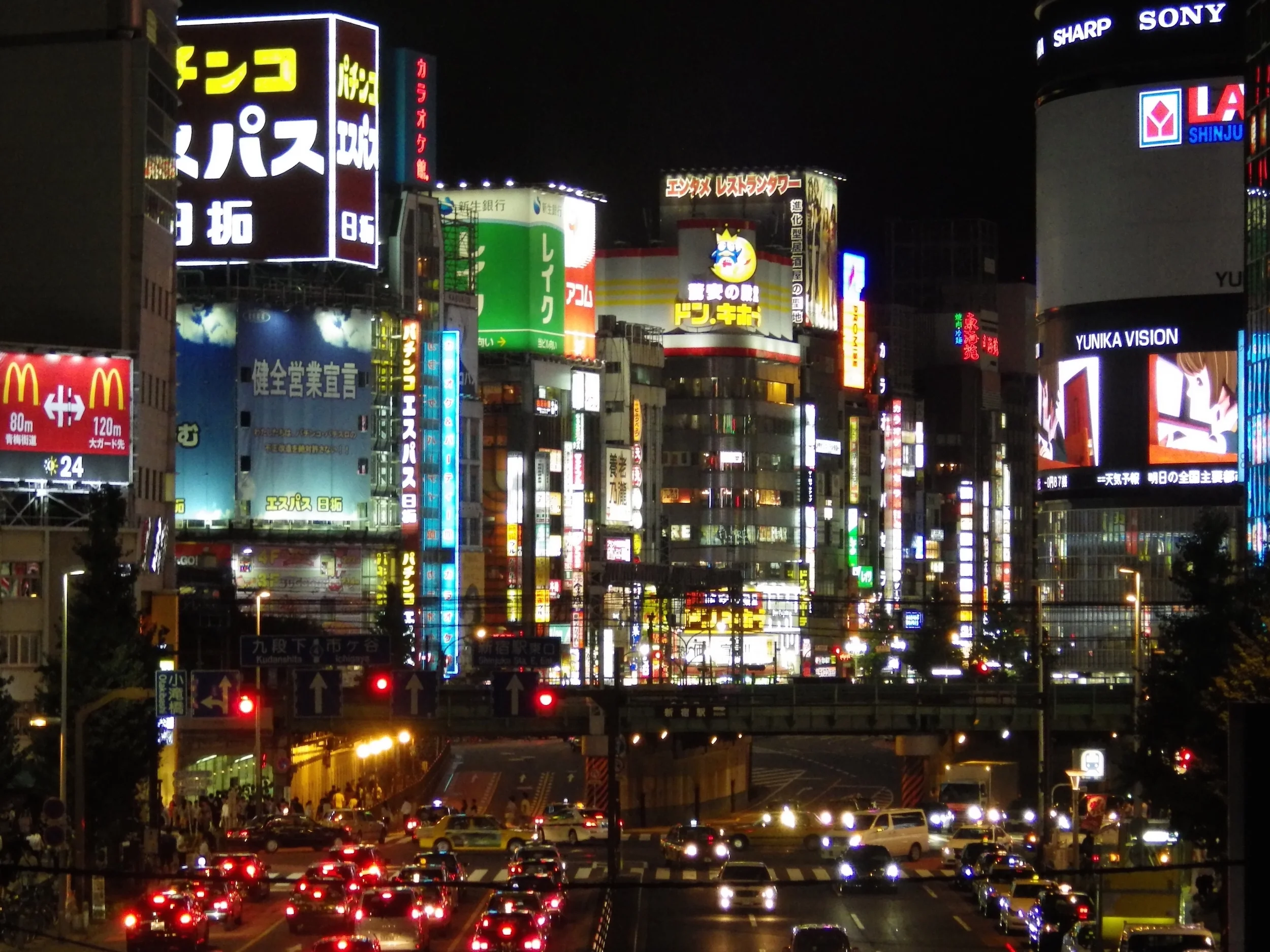 The neon lights of Kabukicho, as seen from a pedestrian bridge over Yasukuni Street in Shinjuku.