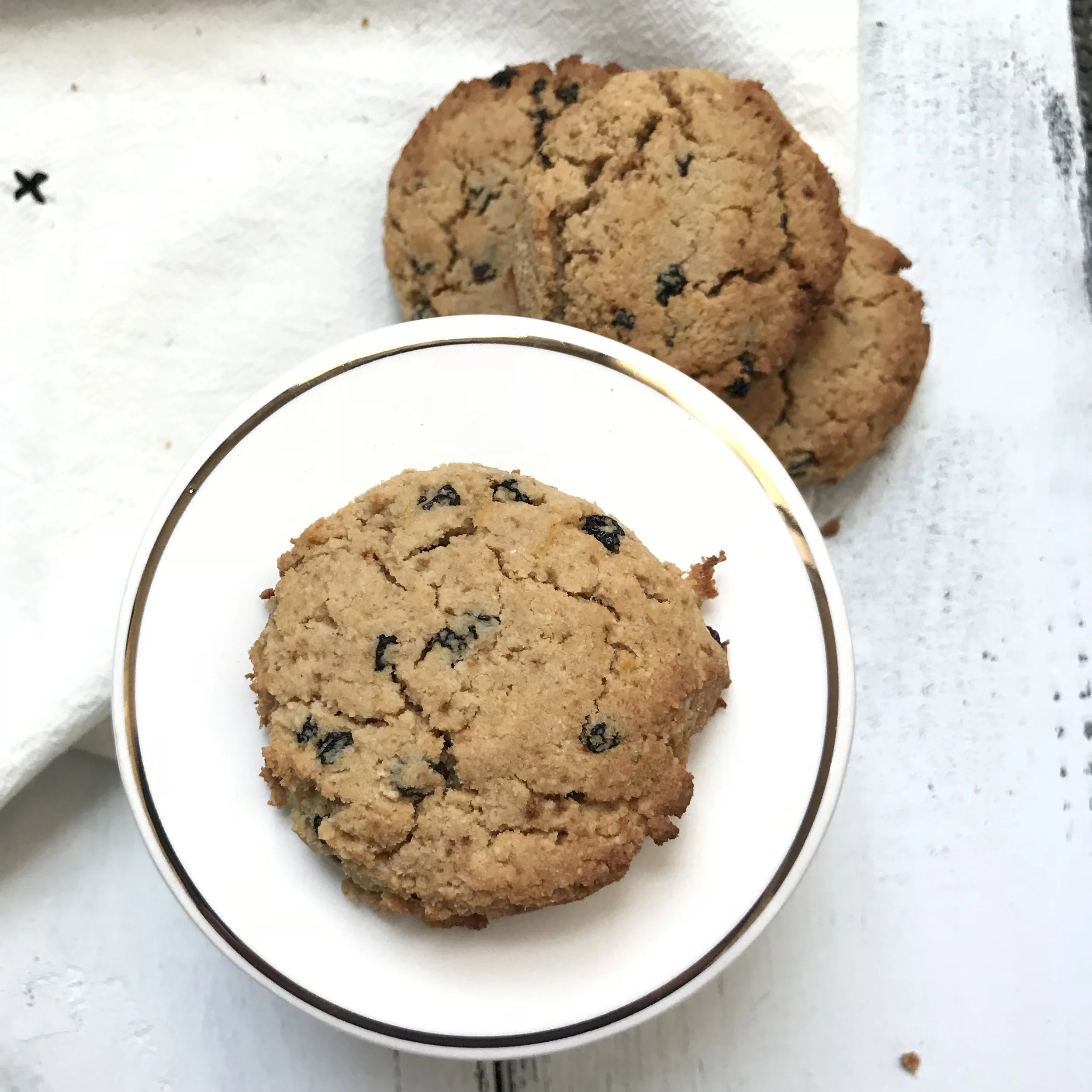 Photo Description: One Lemon Currant Gluten-Free Scone on a round plate with a gold trim and two others to the top right of it