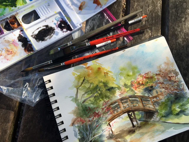 Bridge in the Japanese Garden, along with my watercolor palette and brushes. ©2016 by Erin Blumer.