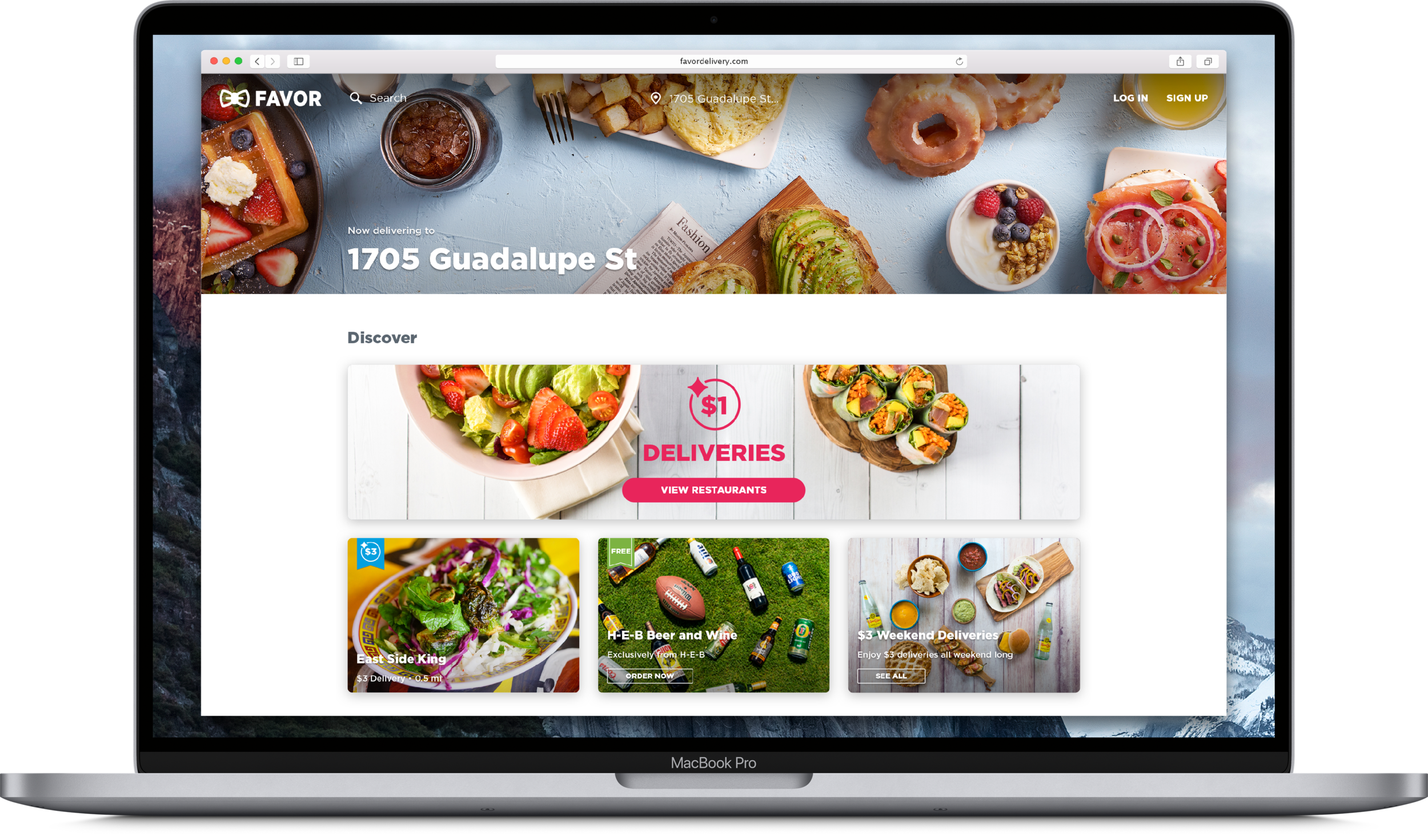 Screenshot of a food delivery website on a MacBook Pro laptop showing various dishes such as salads and Asian rolls, with a navigation bar including the website logo, search option, location, and sign-up buttons.