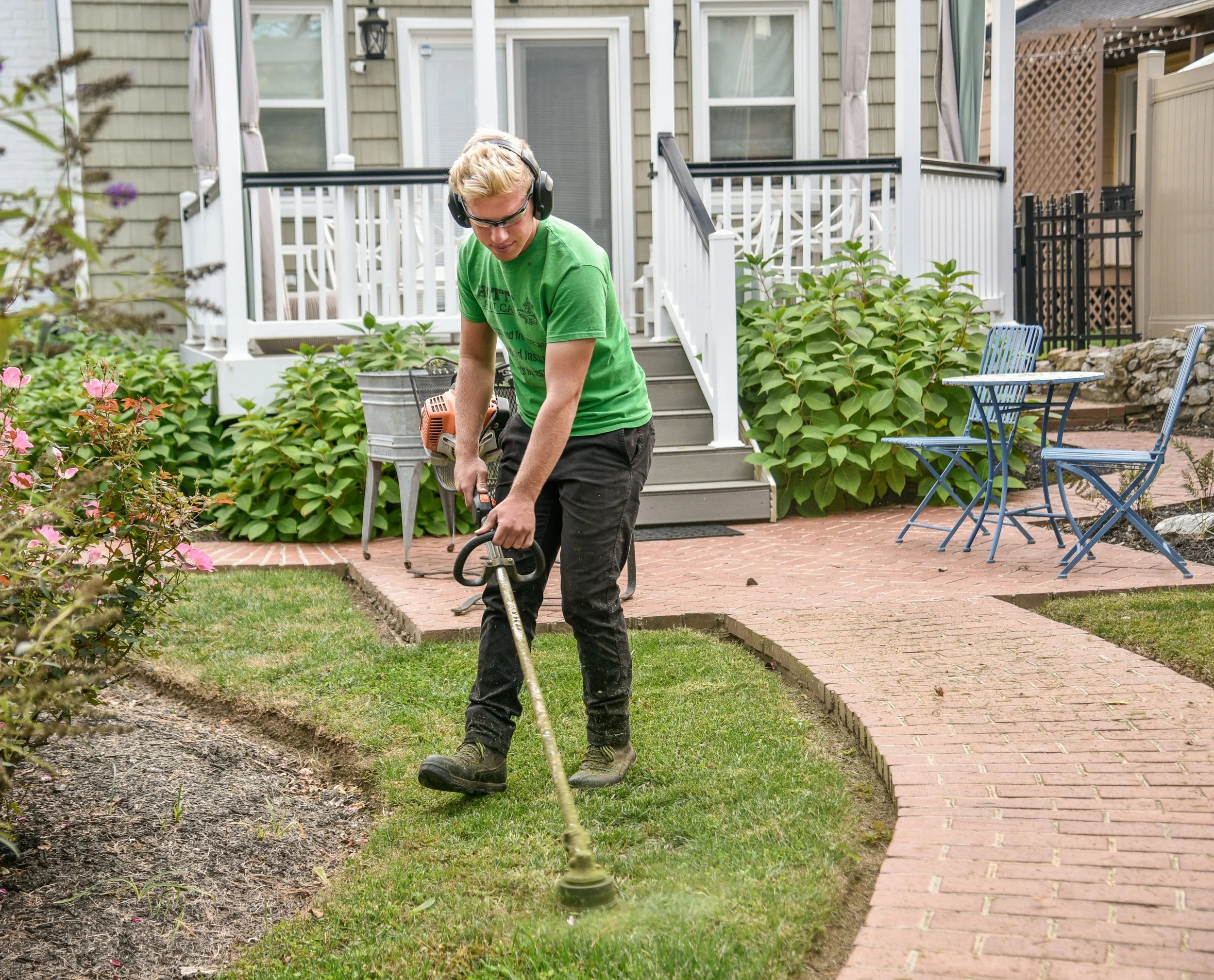 young man doing lawncare with safety glasses on