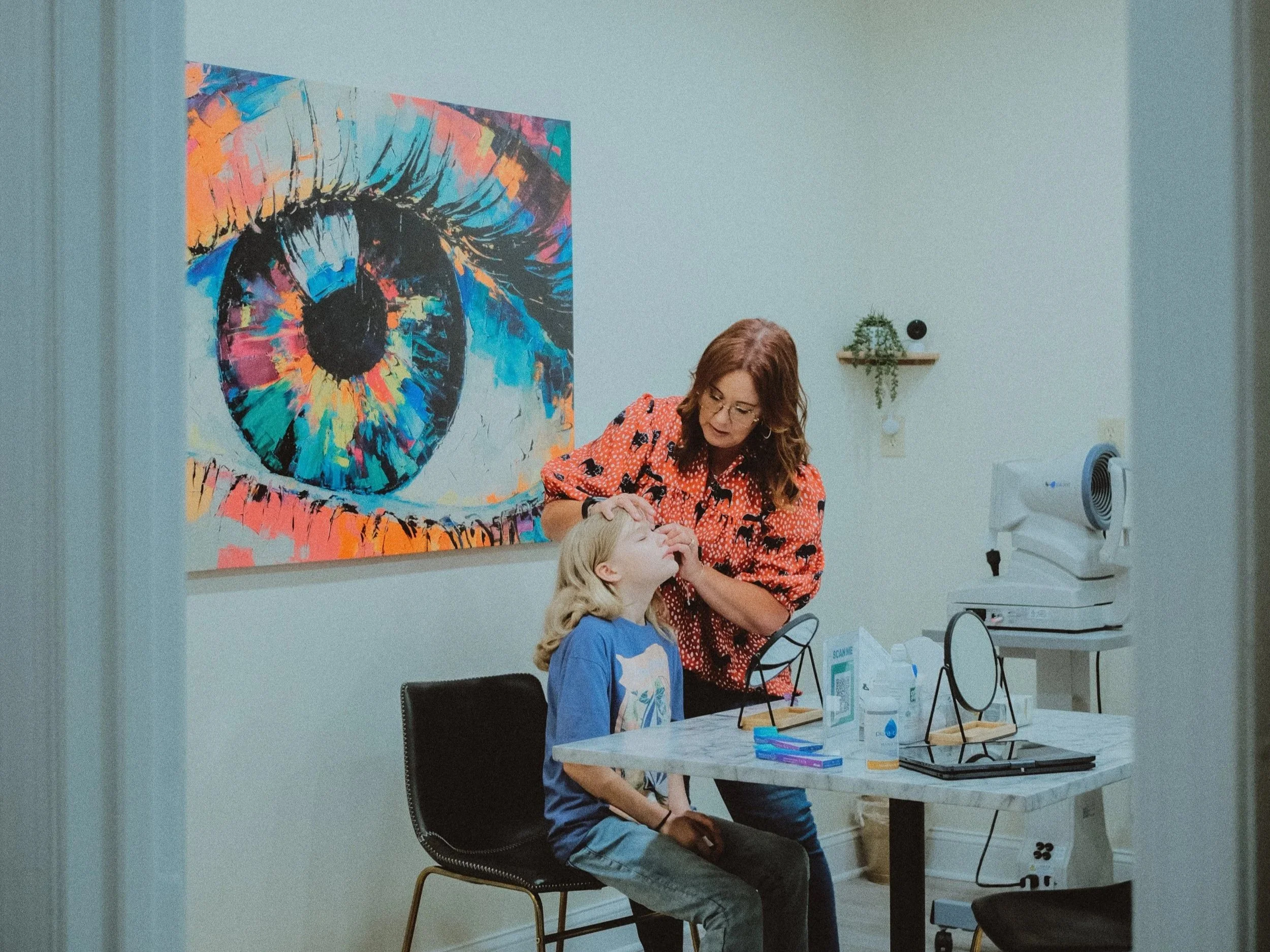 eye specialist helping child with putting in contacts for the first time