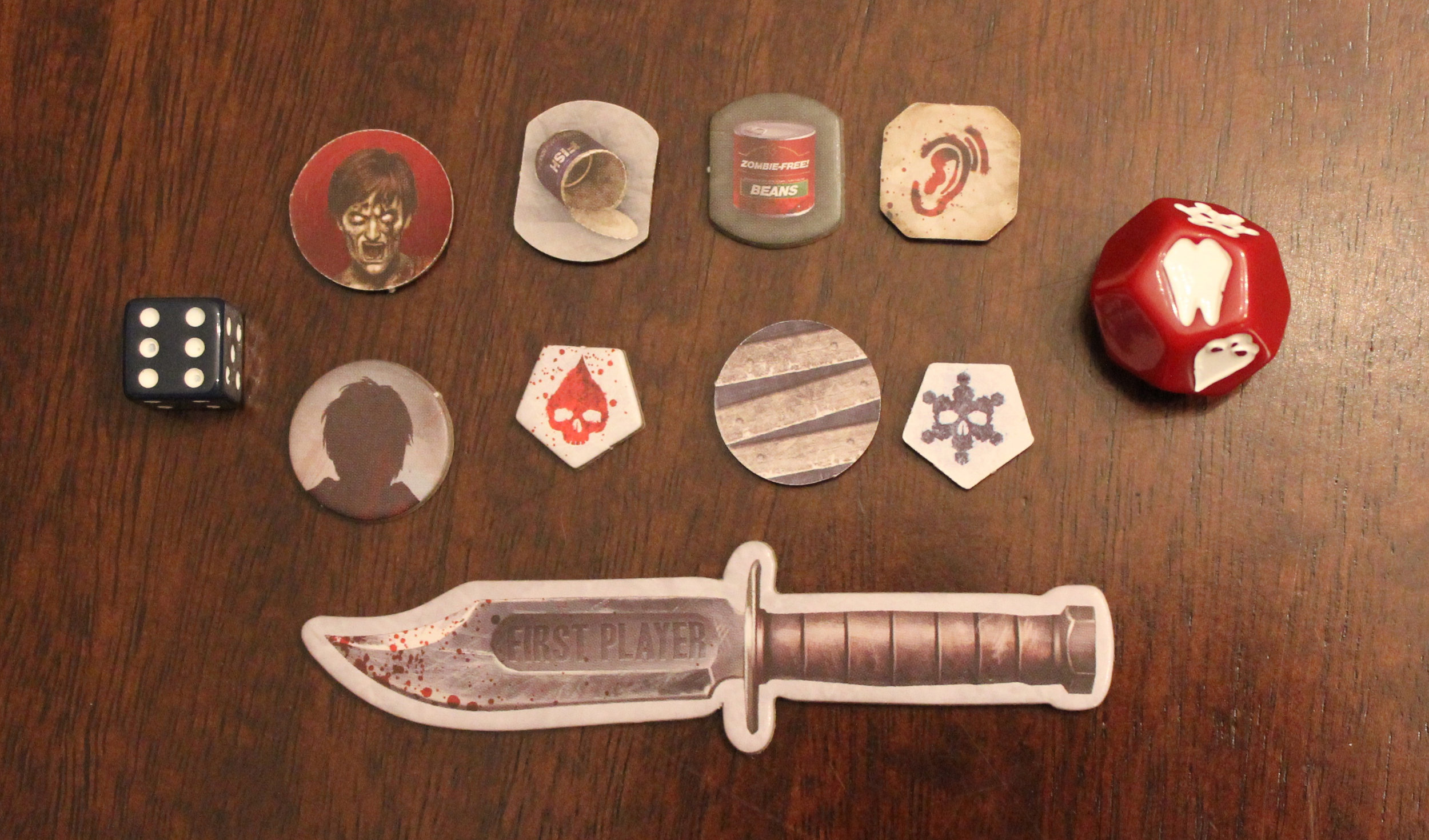 Exposure die is the red one on the right. Also pictured, the knife to indicate first player and the various tokens used throughout the game.