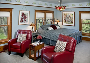 Dakota Suite king-size bed and red leather chairs from the sitting area.