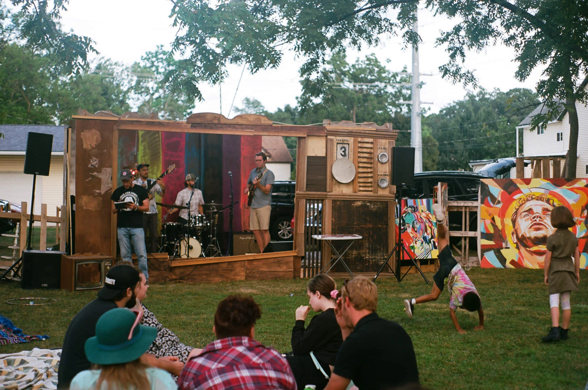 AIRIAR , a band comprising Eli Kahn , Tom Nania , Arthur Schroeder , performs inside the TV set built by Lauren Steinhofer and Jay Jeffcoat while kids do cartwheels.
