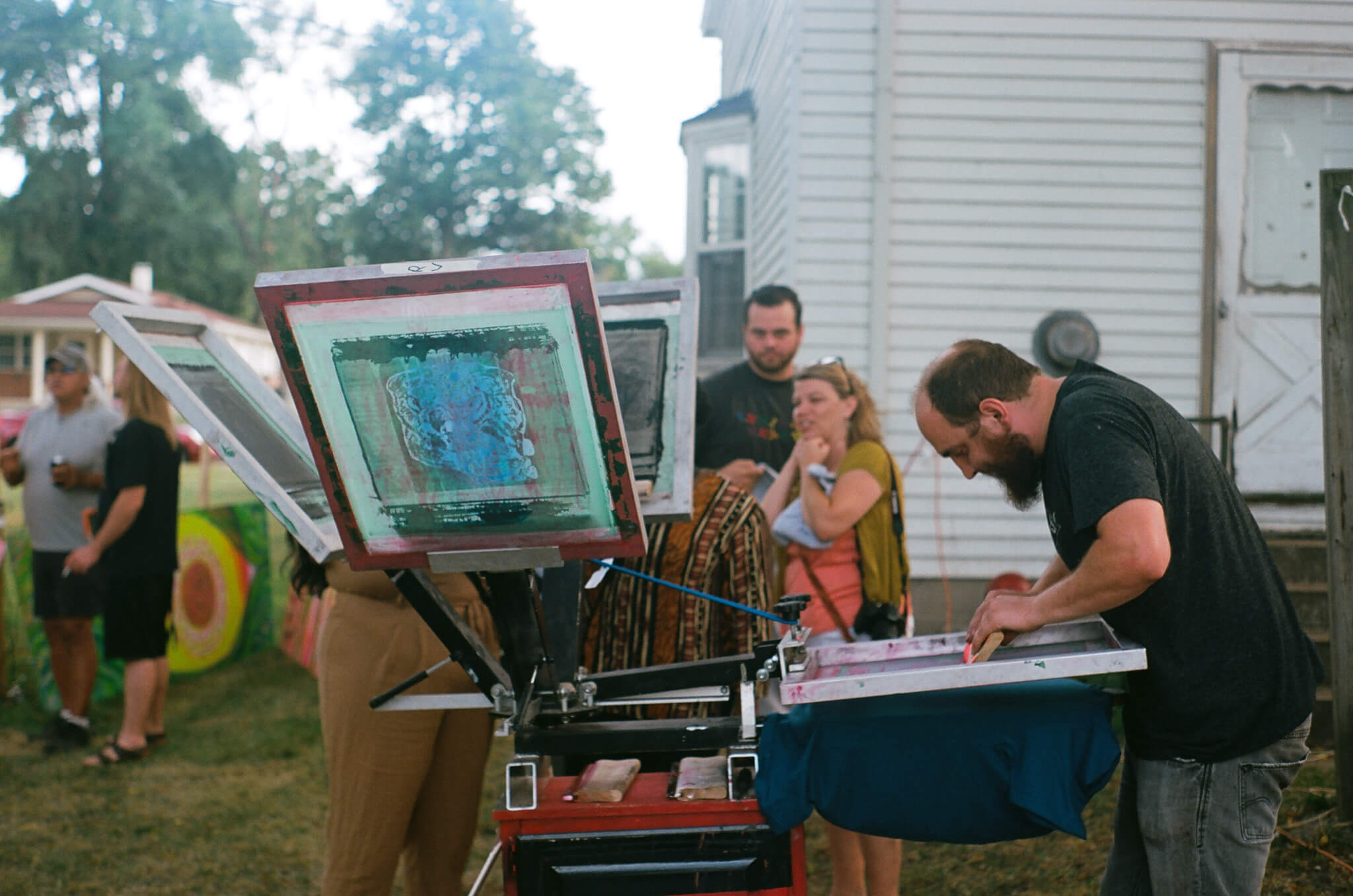 Bradley Davenport , artistic director of Mosaic Studios & Gallery , screen prints custom (Y)ART? tees.