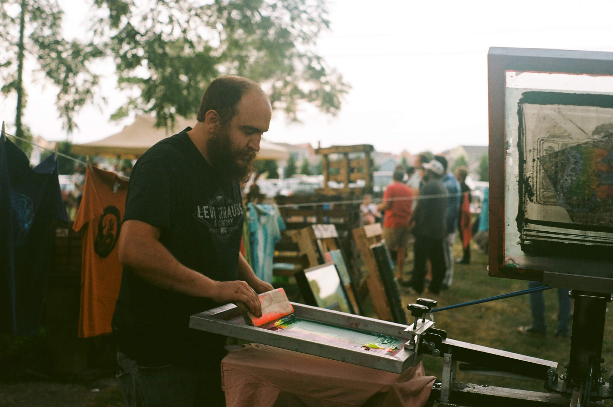 Bradley Davenport , artistic director of Mosaic Studios & Gallery , screen prints custom (Y)ART? tees.