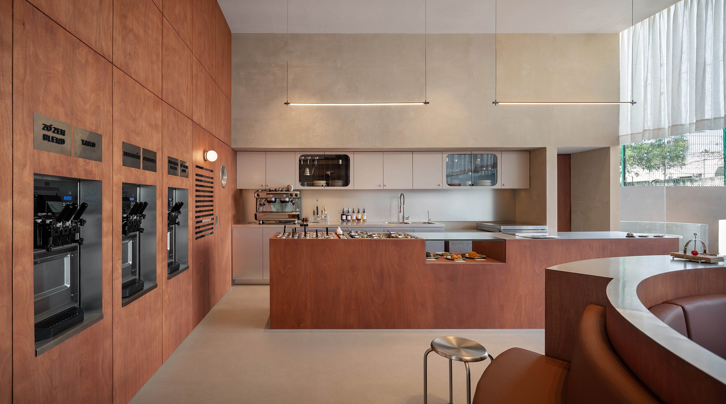 Zo'Zen frozen yogurt shop in San Pedro Garza García designed by Mariel Lozano Studio, featuring teak wood wall paneling, flush-mounted soft serve dispensers, a custom wooden topping counter, and circular leather banquette seating.