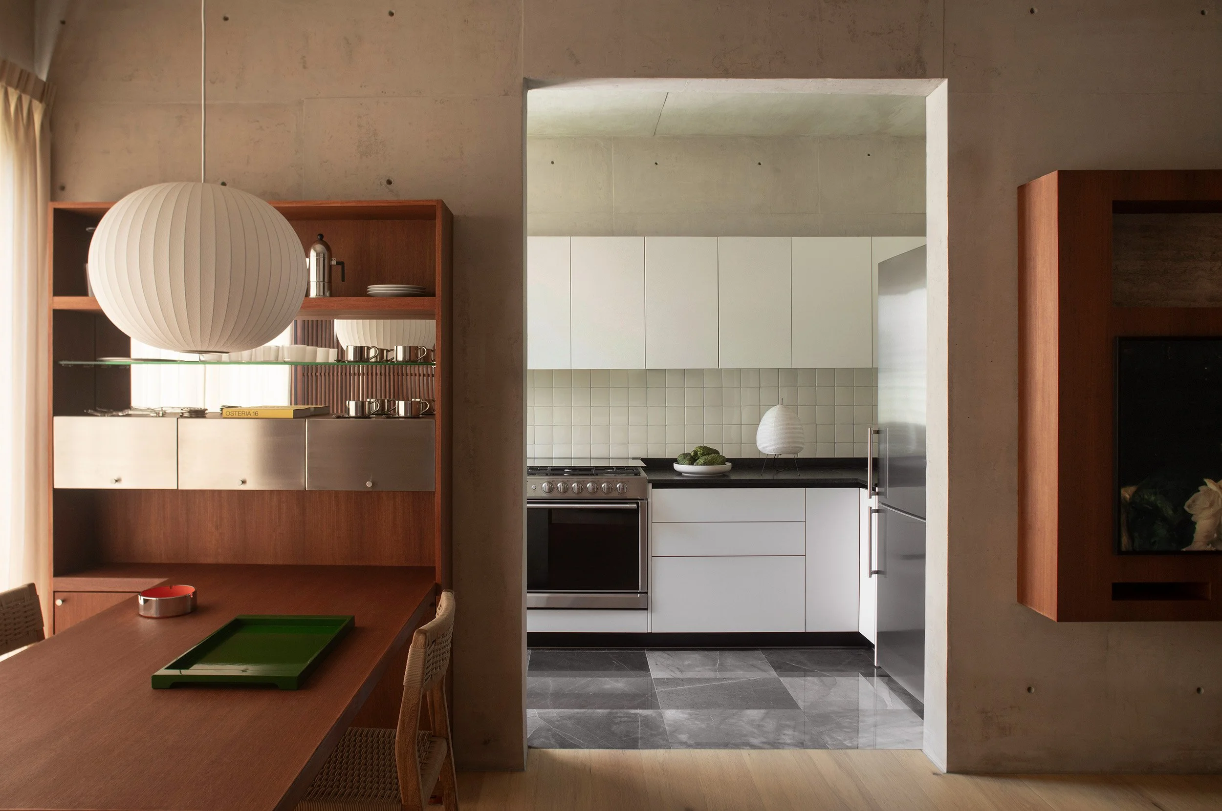 Apartment layout showing the dining area with a Nelson Bubble lamp, a kitchen and a TV unit at San Luis apartment in Mexico City by Mariel Lozano Studio, photo by Fabian Martinez.