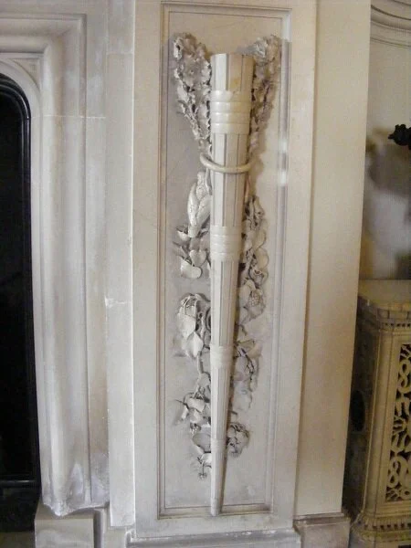 One of a pair of torches flanking the chimneypiece, carved from marble