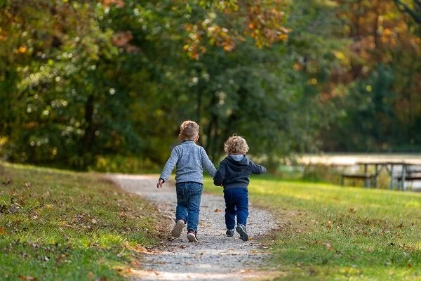 little boys, holding hands, blue jeans, blue shirts, running, path, grass