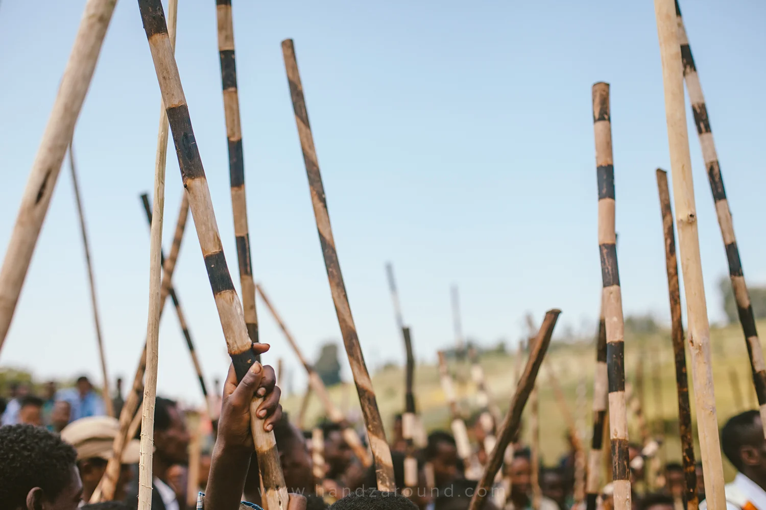 Local boys and men holding up their traditional weapons
