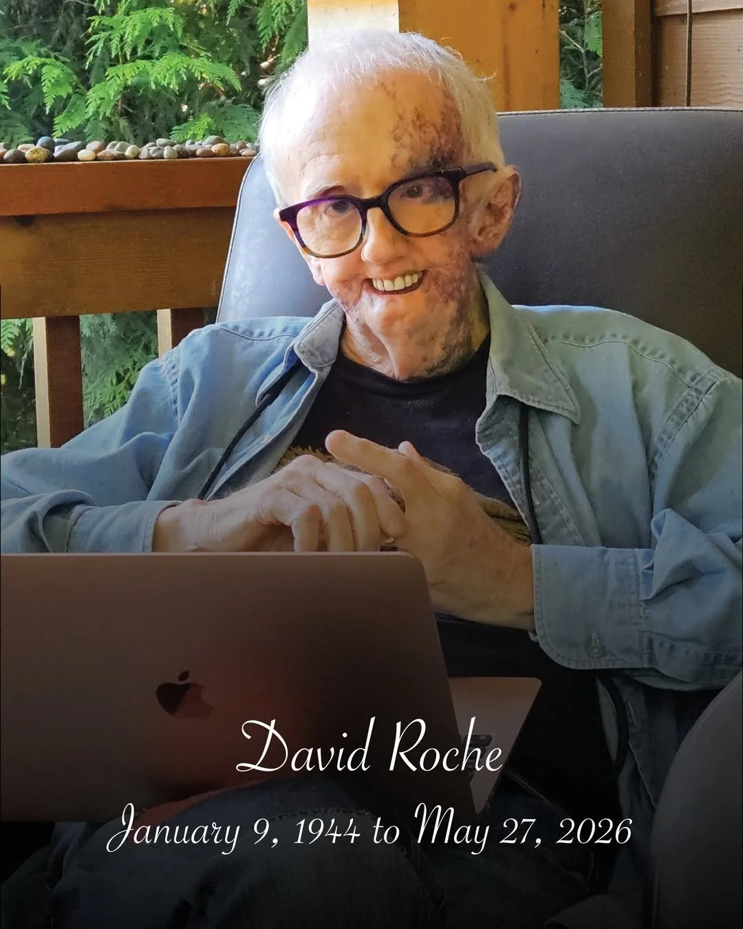 Photo of smiling David Roche with his laptop, memorial dates: January 9, 1944 - May 27, 2026