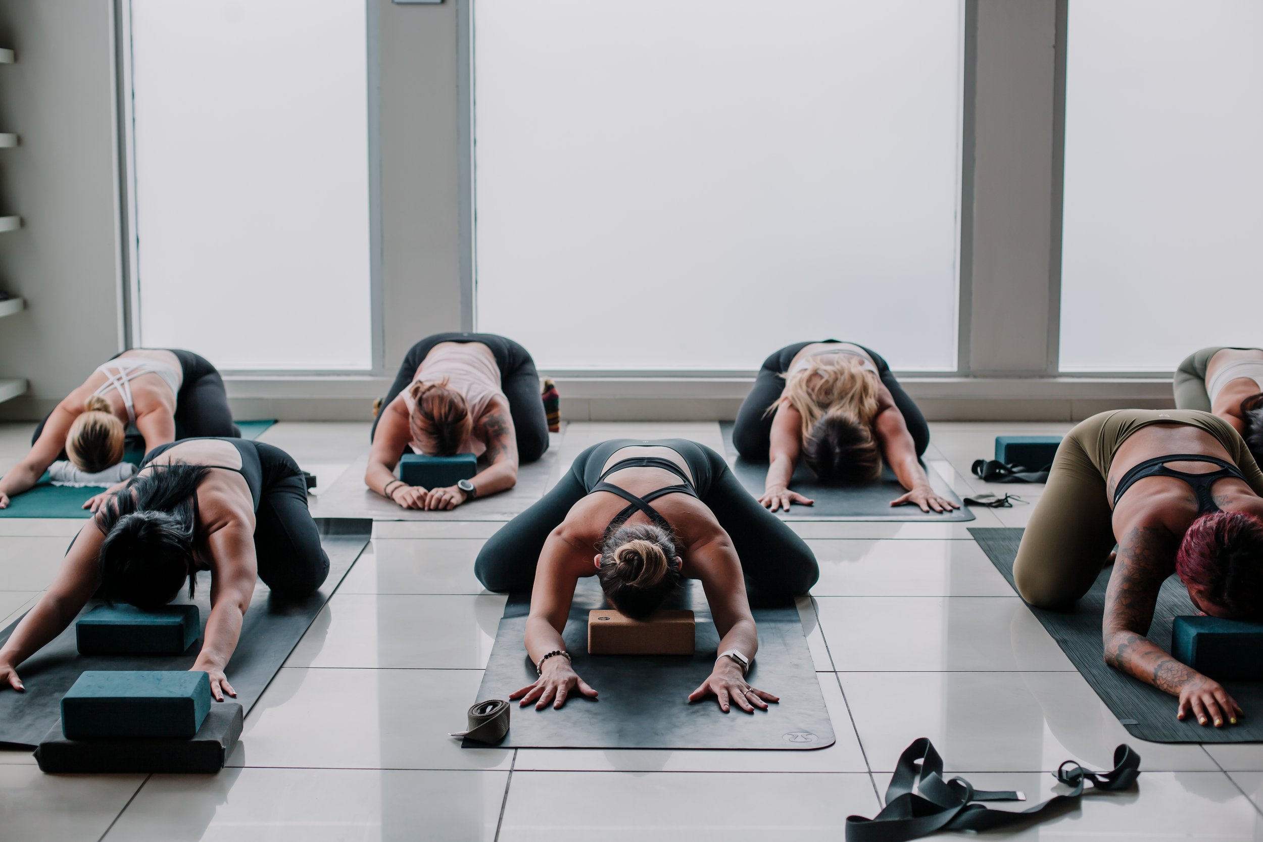 happy group of people of three women practicing yoga in the studio