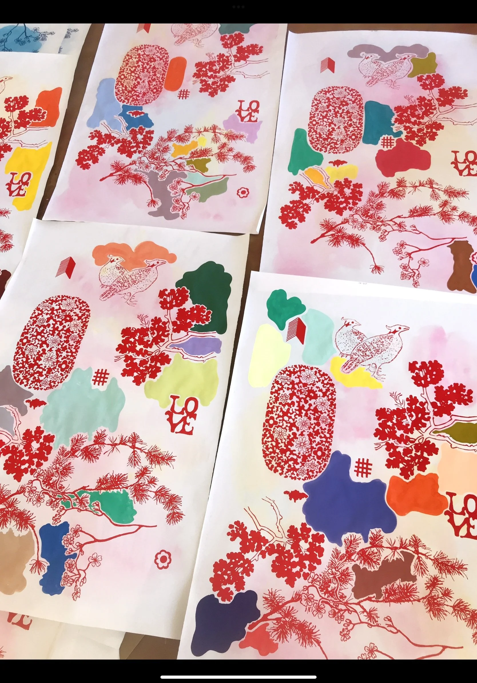 Colorful artistic prints featuring red, pink, blue, green, yellow, orange, and purple abstract shapes, trees, and birds with a central theme of love, as indicated by the word "LOVE" in red on some prints.
