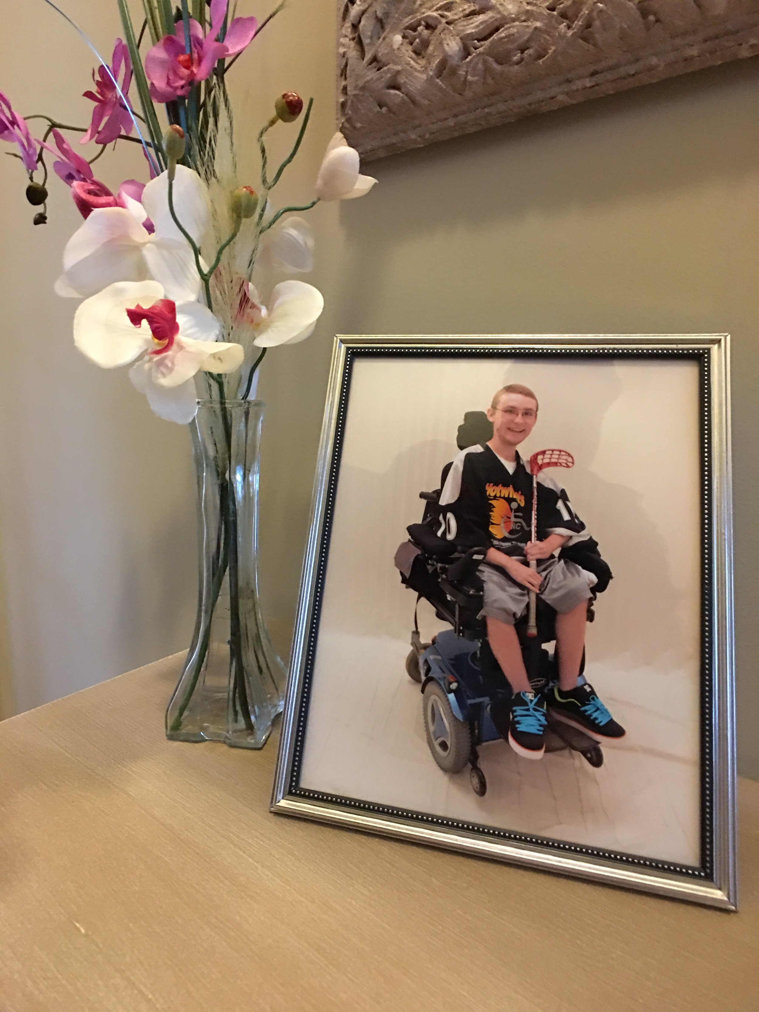 In their foyer, a photo of son, Justin. He was an intelligent, vigrant young man who loved playing adaptive floor hockey, video games and loved to pursue girls.