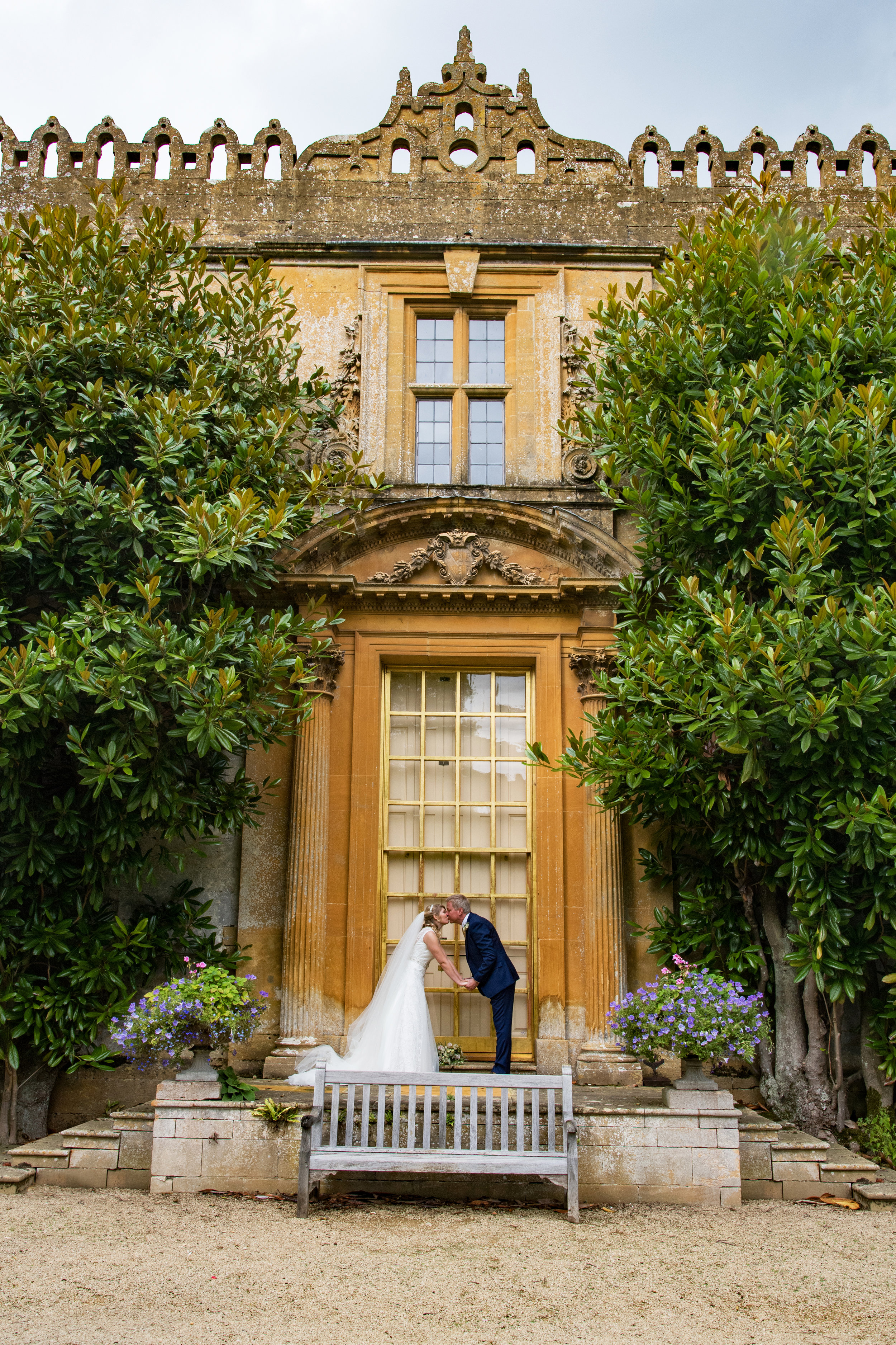 Bride and groom kiss at Historic Stanway House and fountain