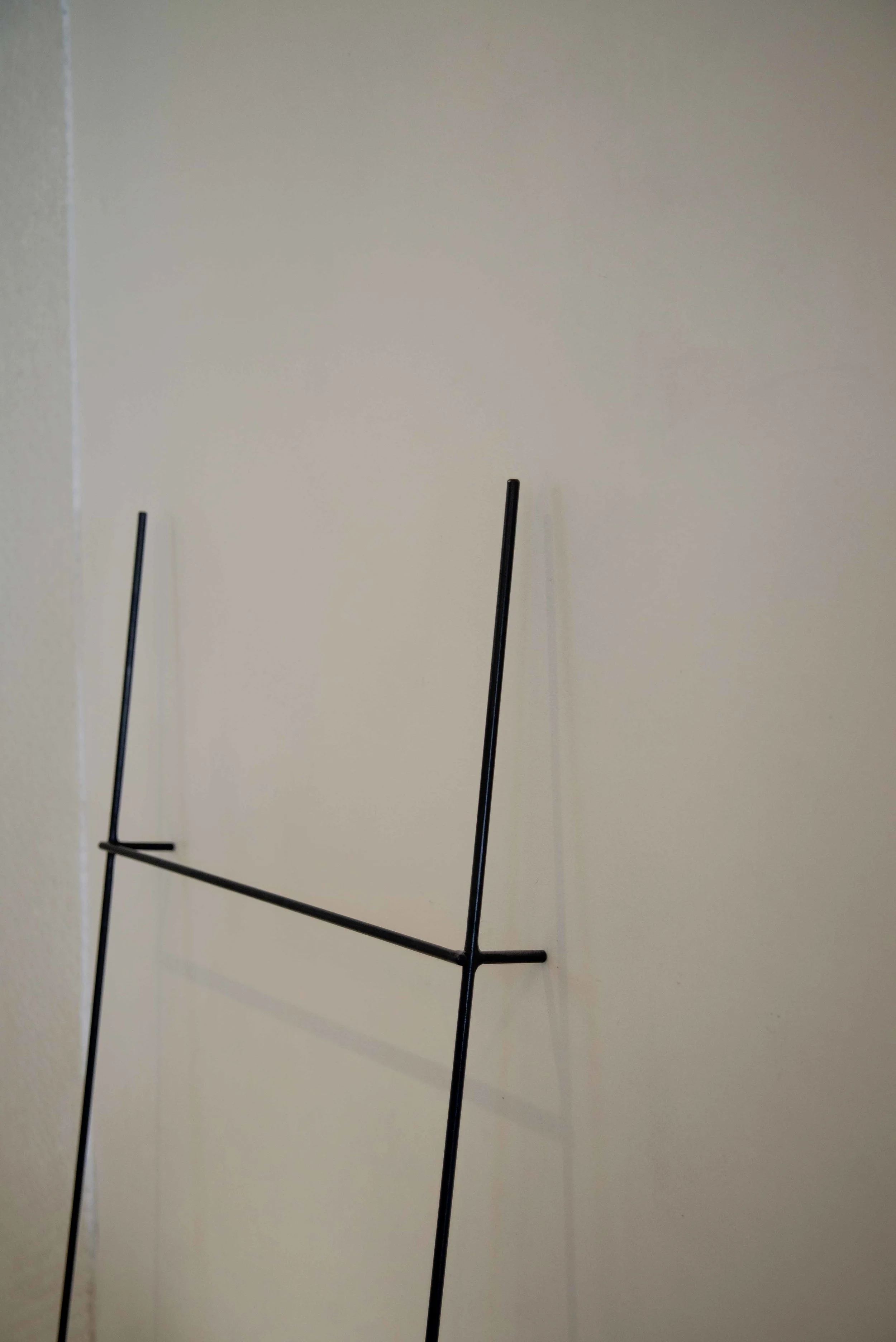 Matt black steel rod standing towel rail.