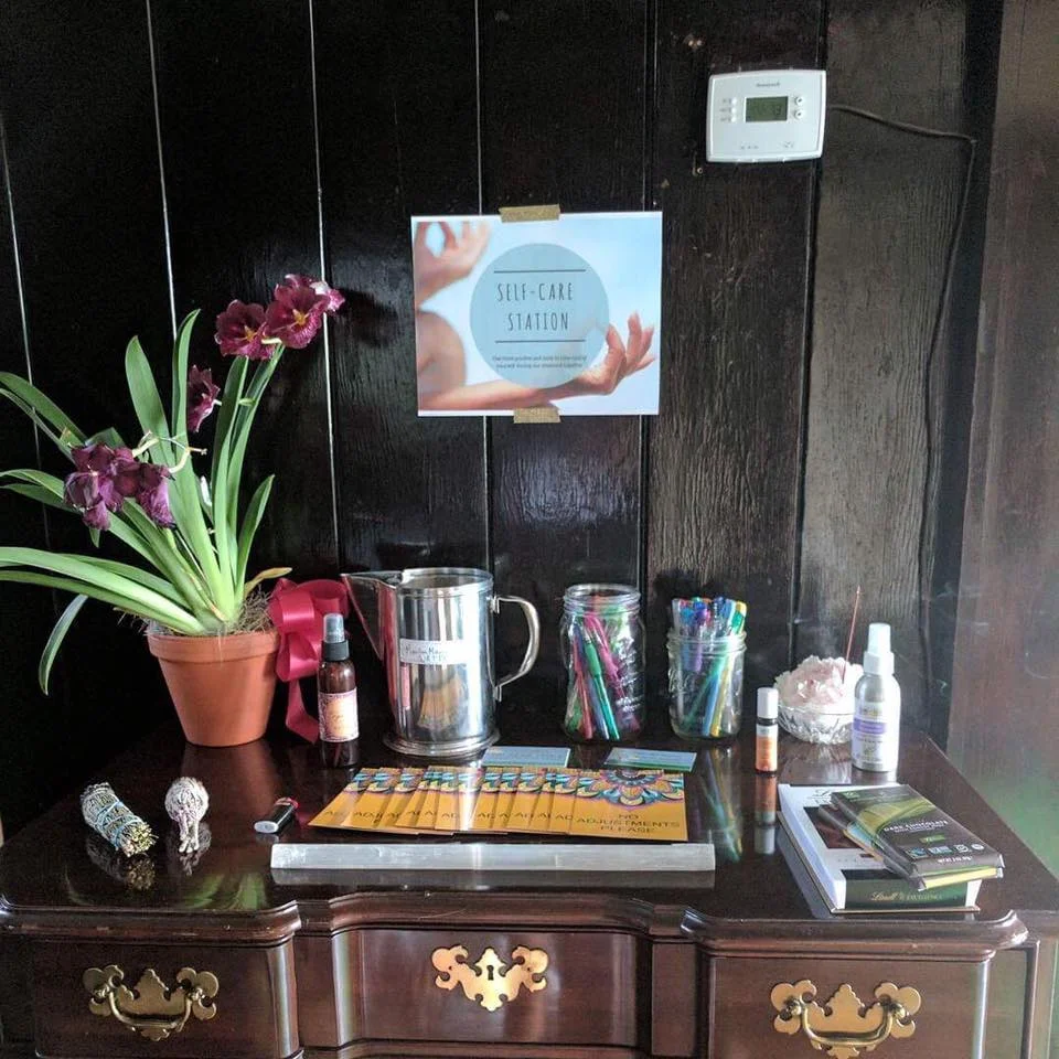 Setting up a Self-Care Station for all of the students to use throughout the weekend: organic dark chocolate, 'No Adjustment' cards, sage, incense, fresh mineral water, sacral chakra essential-oil-blend, lavender spray, rosewater spray, a selenite wand, and an assortment of beautiful flowers. 