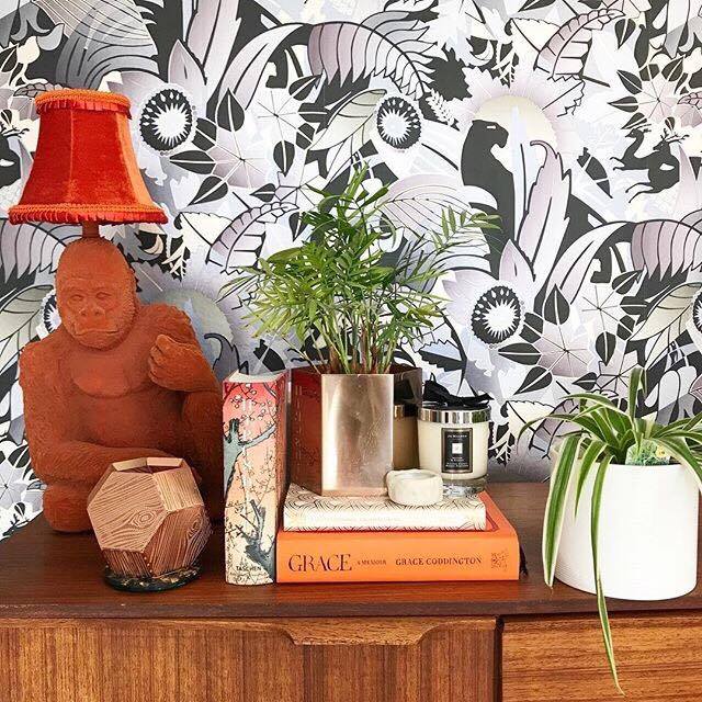 This is Jade from Numberfiveinteriors home.This monochrome wallpaper looks so good as a backdrop for a cluster of orange gold and cream objects. Using the same or similar colours is a great way to cluster objects to create maximum impact.
