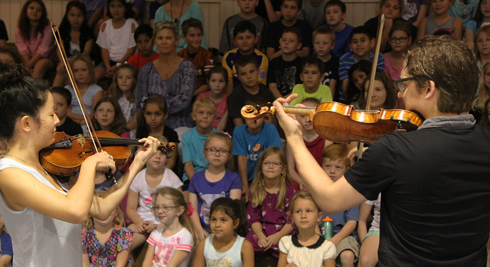 Violinists Rachel Shapiro and Nicholas Tavani, members of t he Aeolus Quartet, perform and teach children at Sacred Heart Catholic School in La Grange.