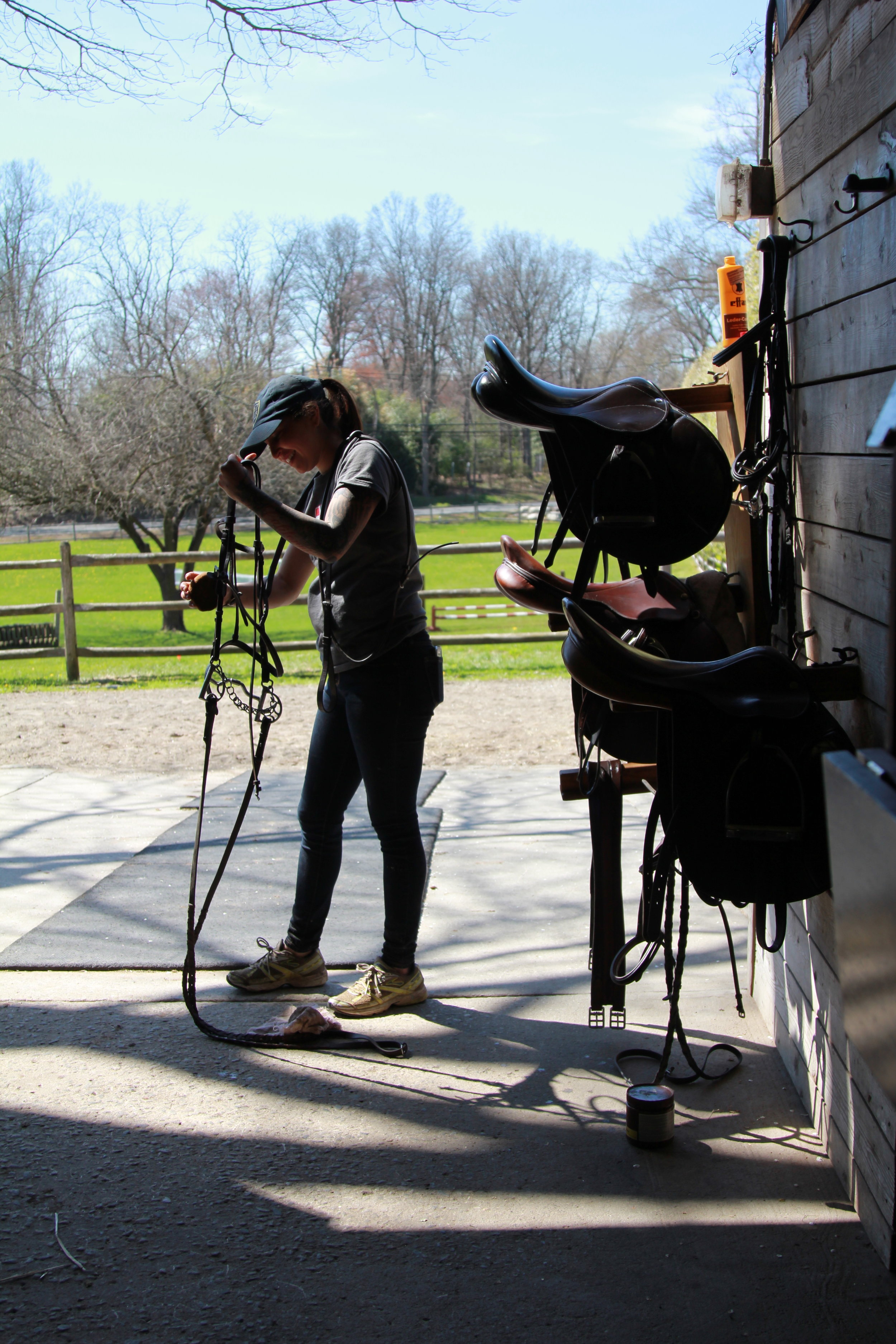 Vanessa cleaning tack after a horseback ride