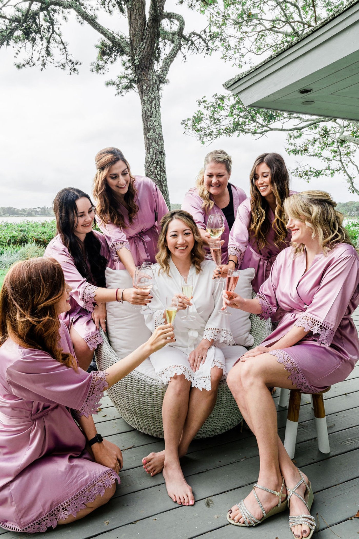 Bride getting ready with her bridesmaids in matching ivory and lavender robes
