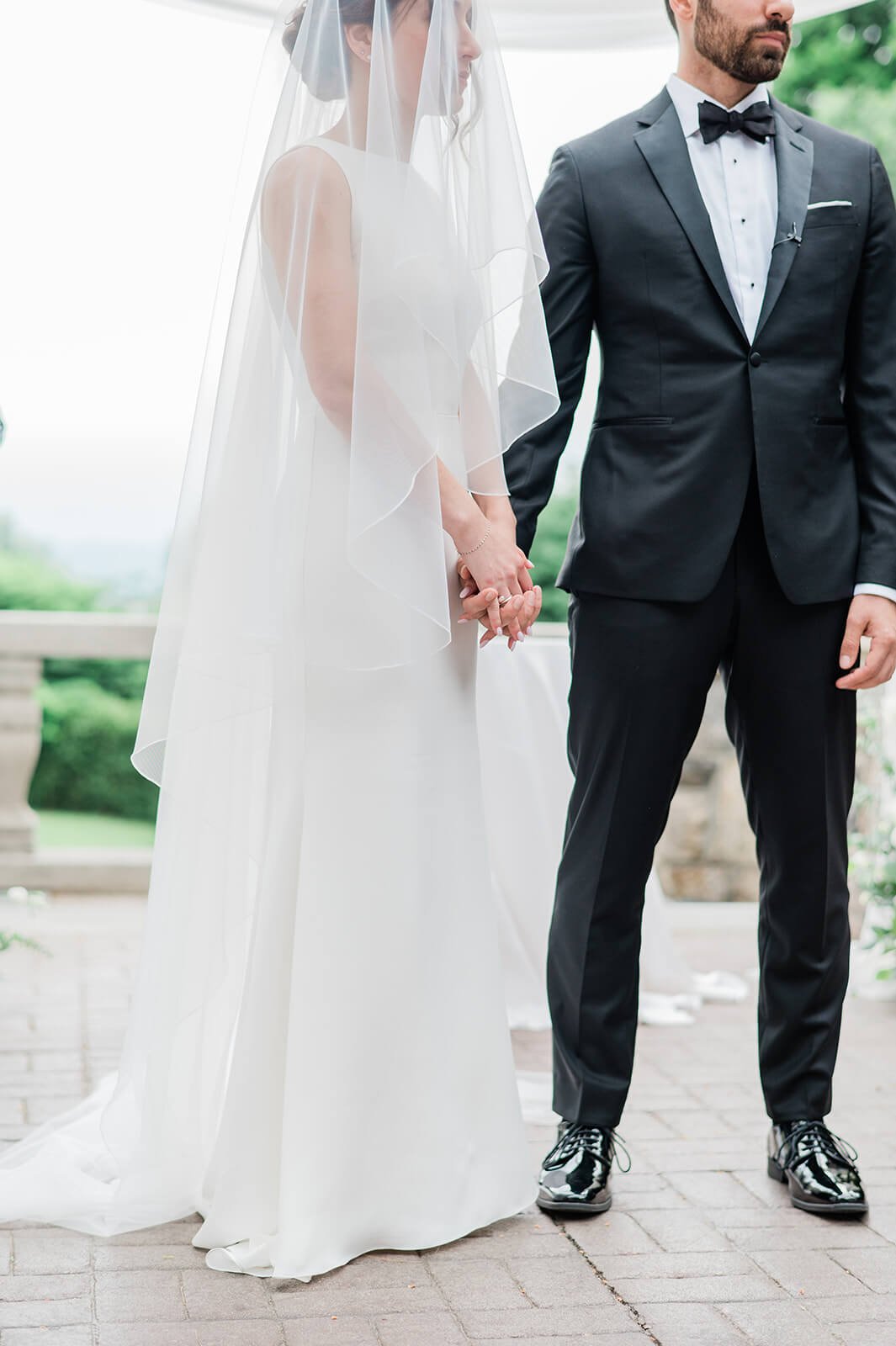 Couple holding hands during their Jewish ceremony